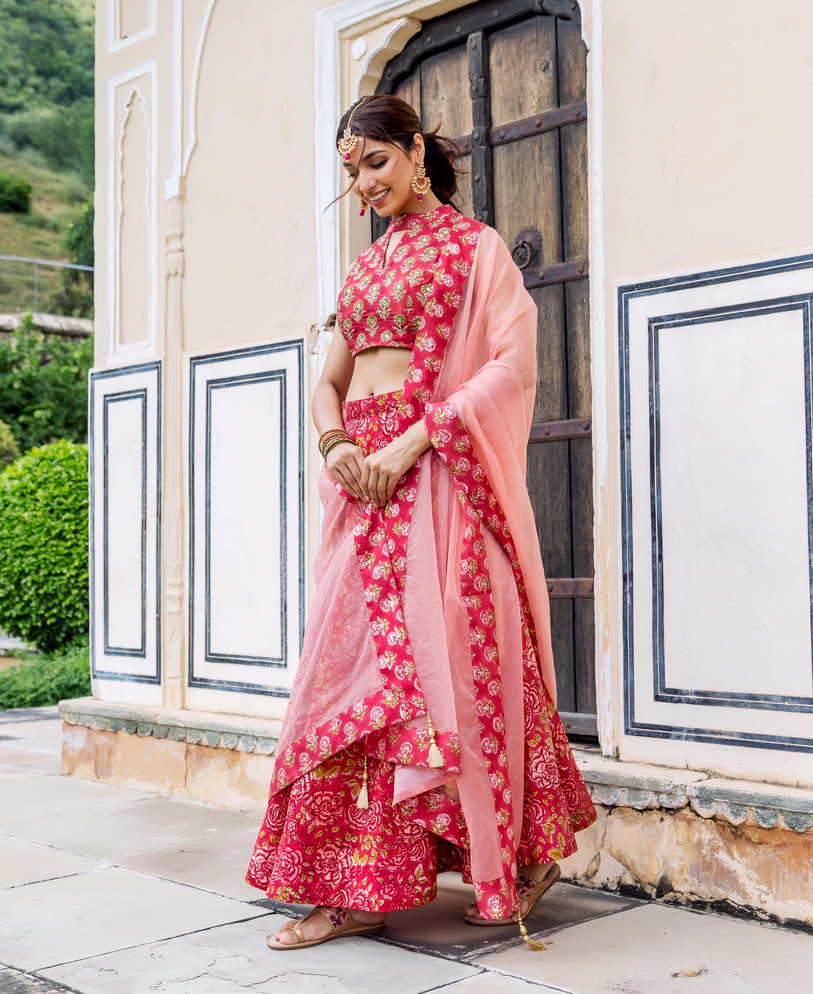 Model in vibrant pink hand-block printed and embroidered floral lehenga set.
