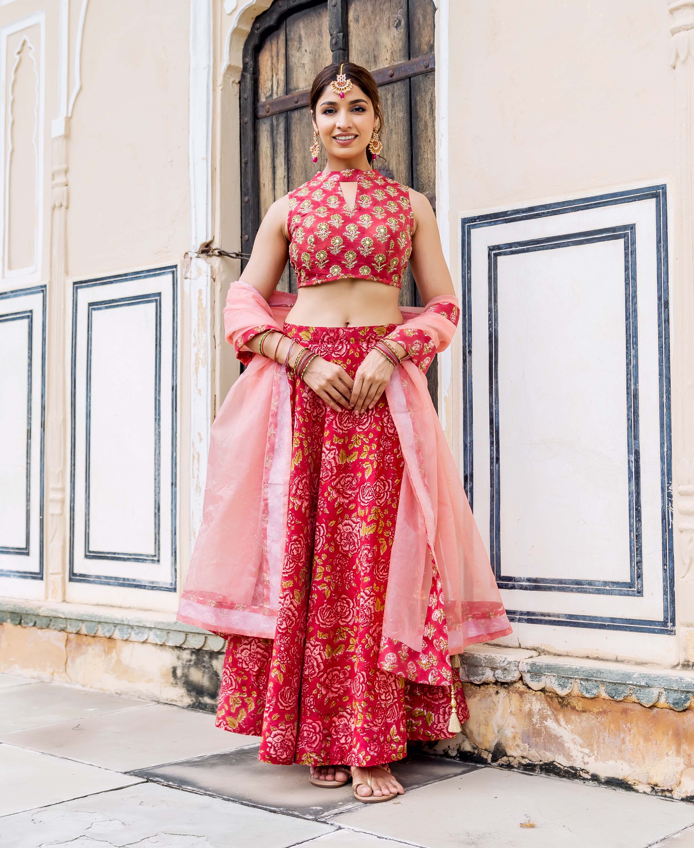 Model in vibrant red hand block printed floral and embroidered lehenga set.