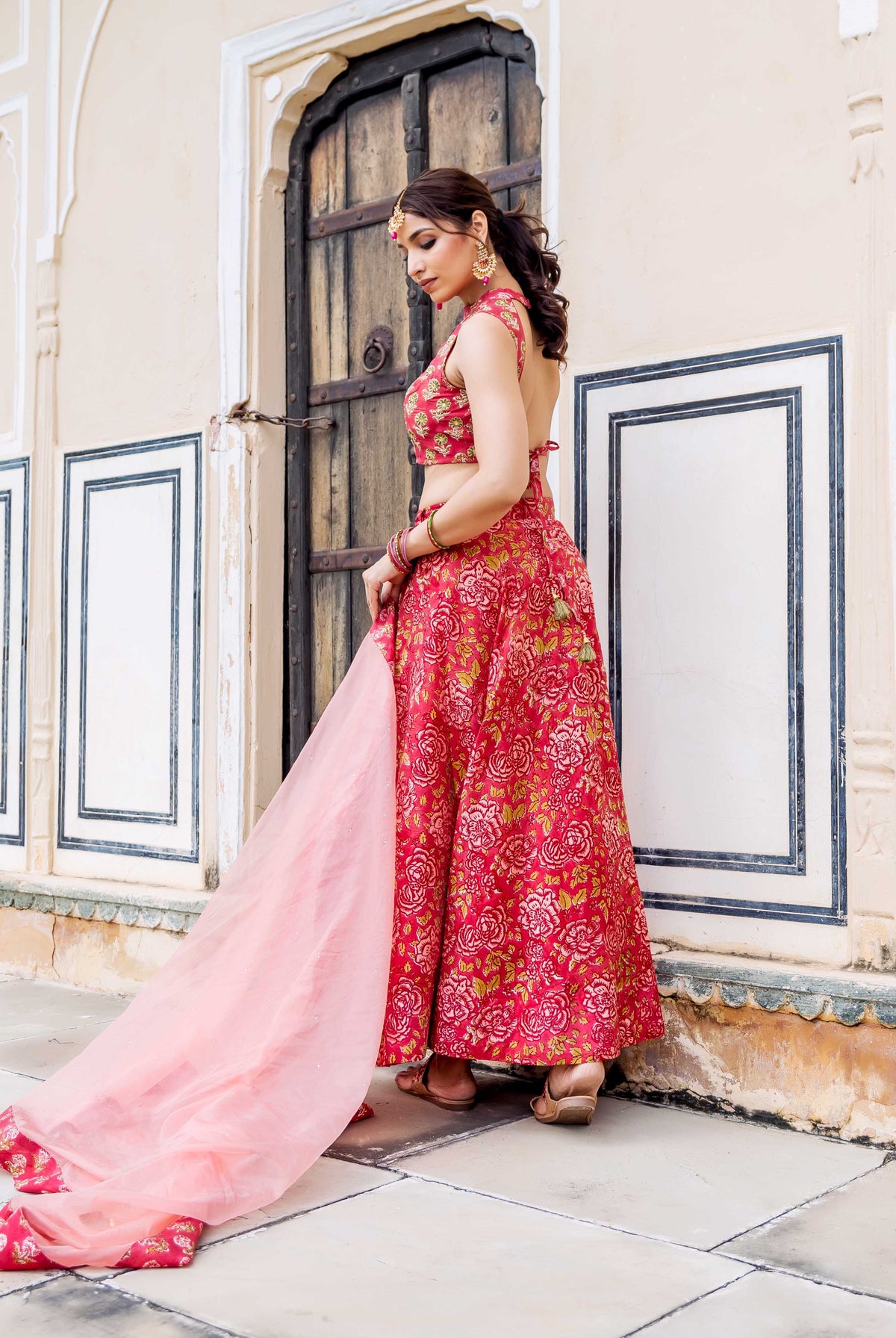 Woman in red hand-block printed floral lehenga set with a light pink dupatta.
