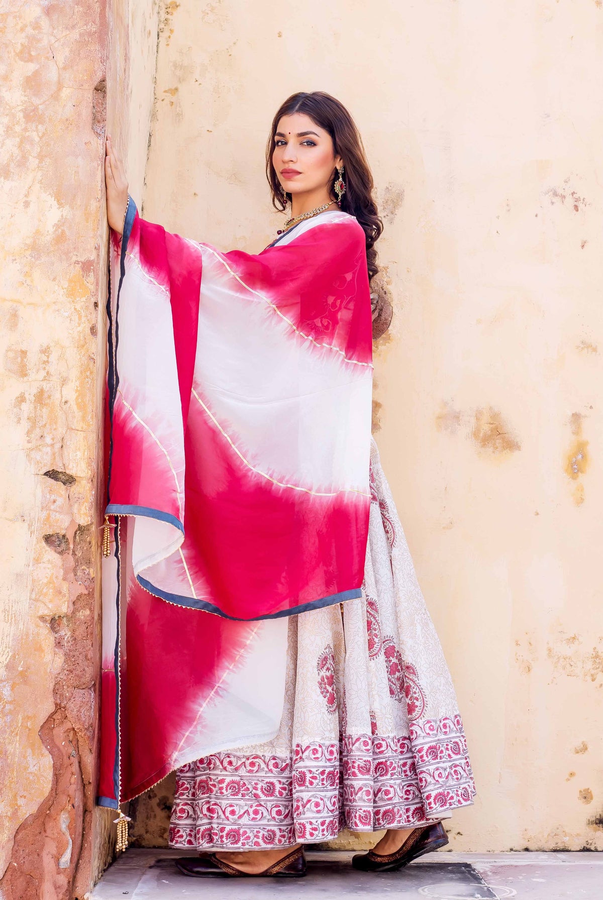 Model in full-length Zoya hand-block printed lehenga with vibrant pink-white bandhani dupatta.