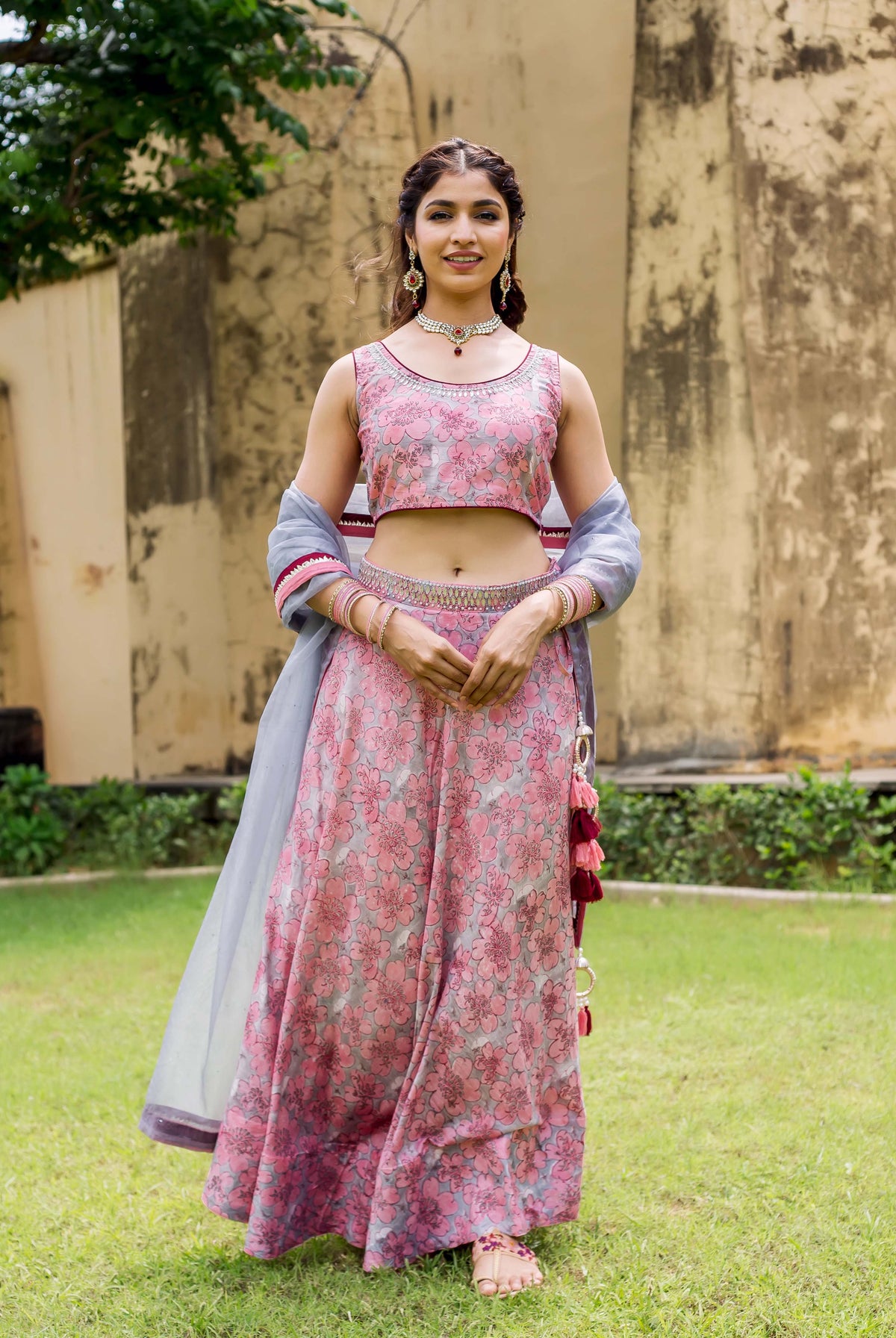 Front full look of a model in pink and grey hand block printed floral lehenga set.