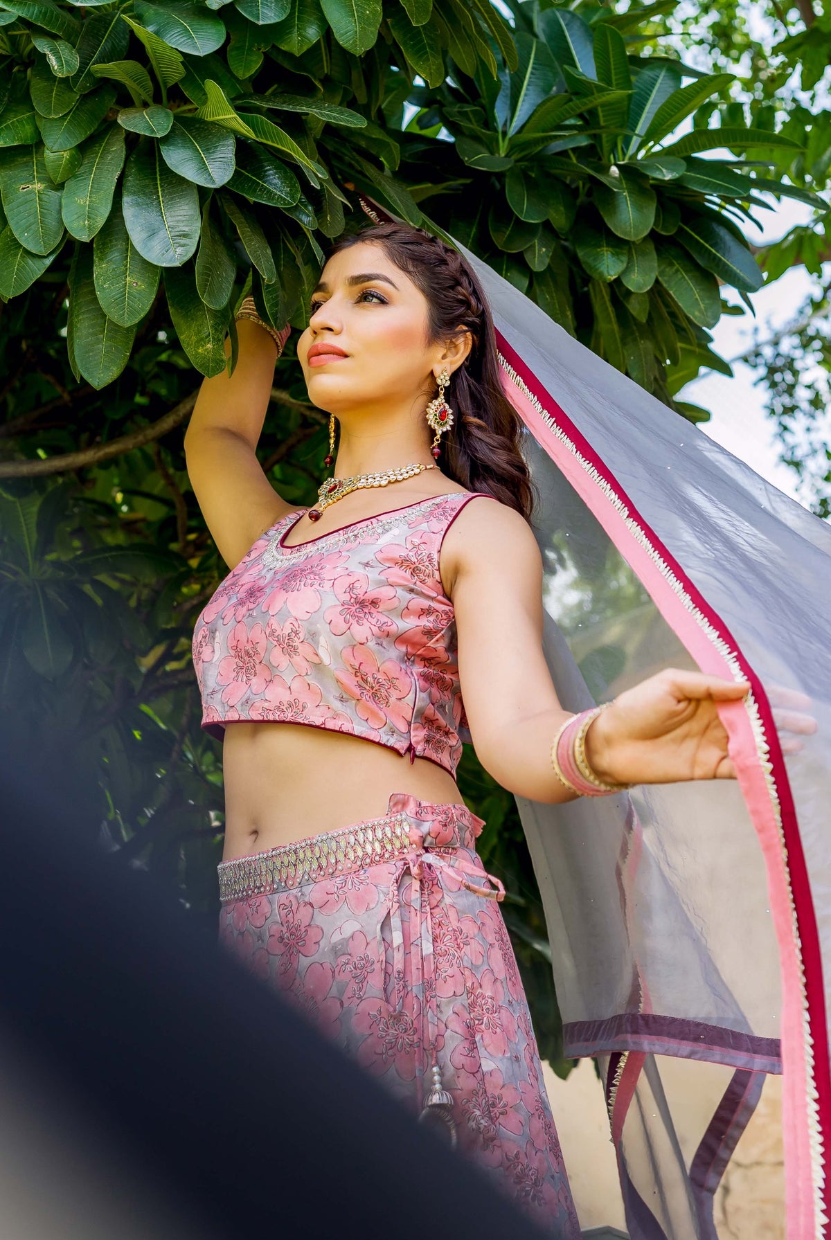 Model in pink and grey floral hand block printed lehenga set with flowing dupatta.