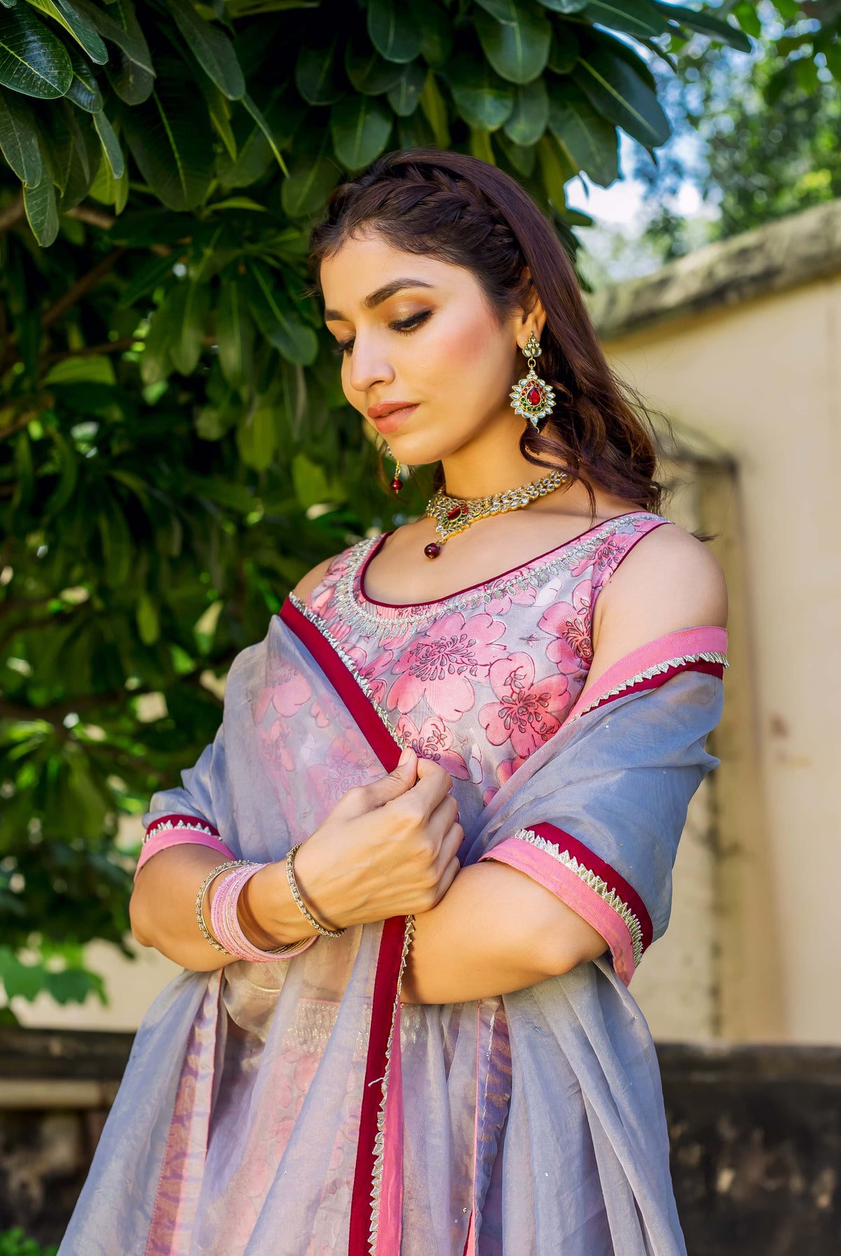 Pink and grey hand-block printed lehenga set on model with floral pattern and trim.