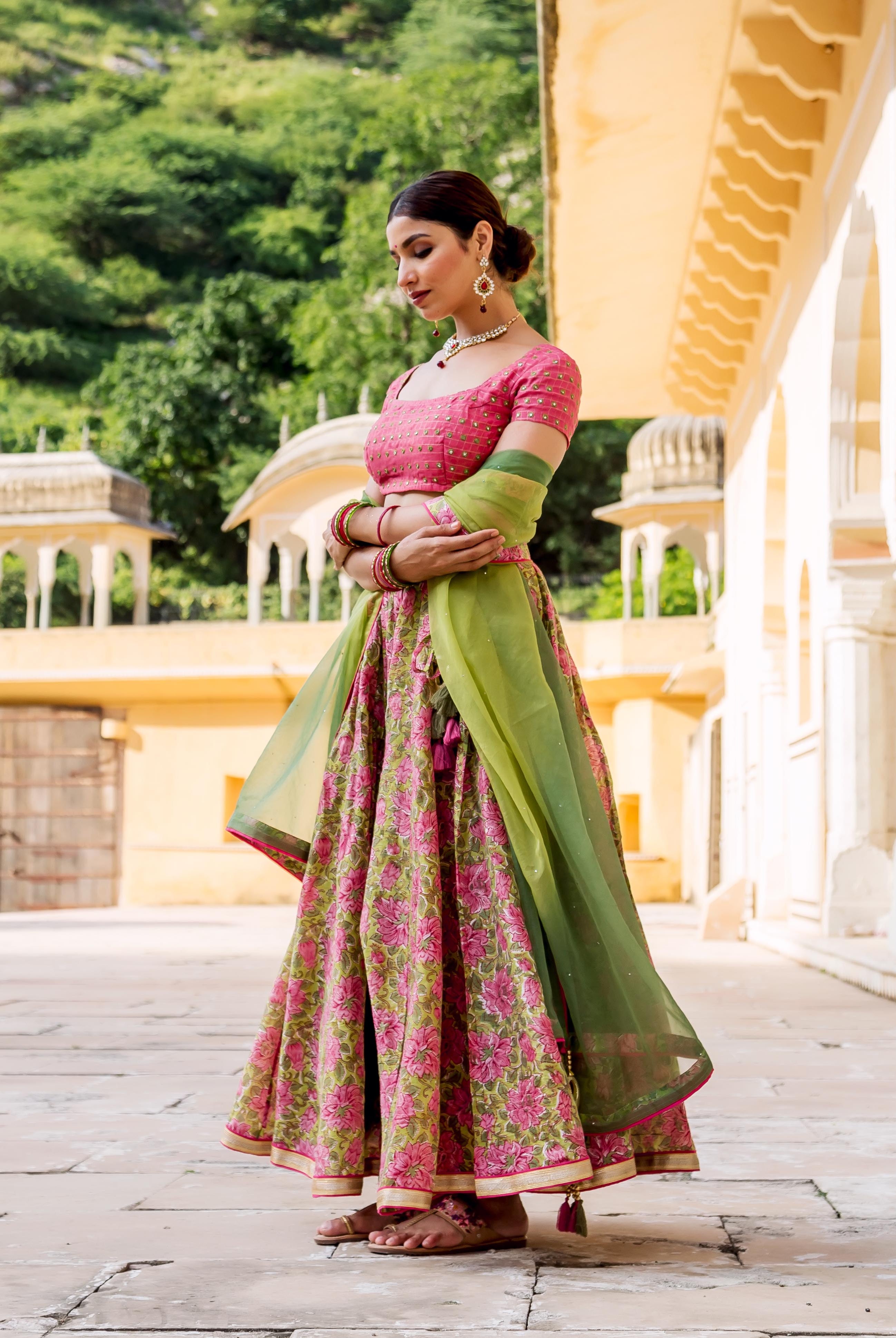 Model in full side view, pink and olive hand block printed lotus lehenga set.