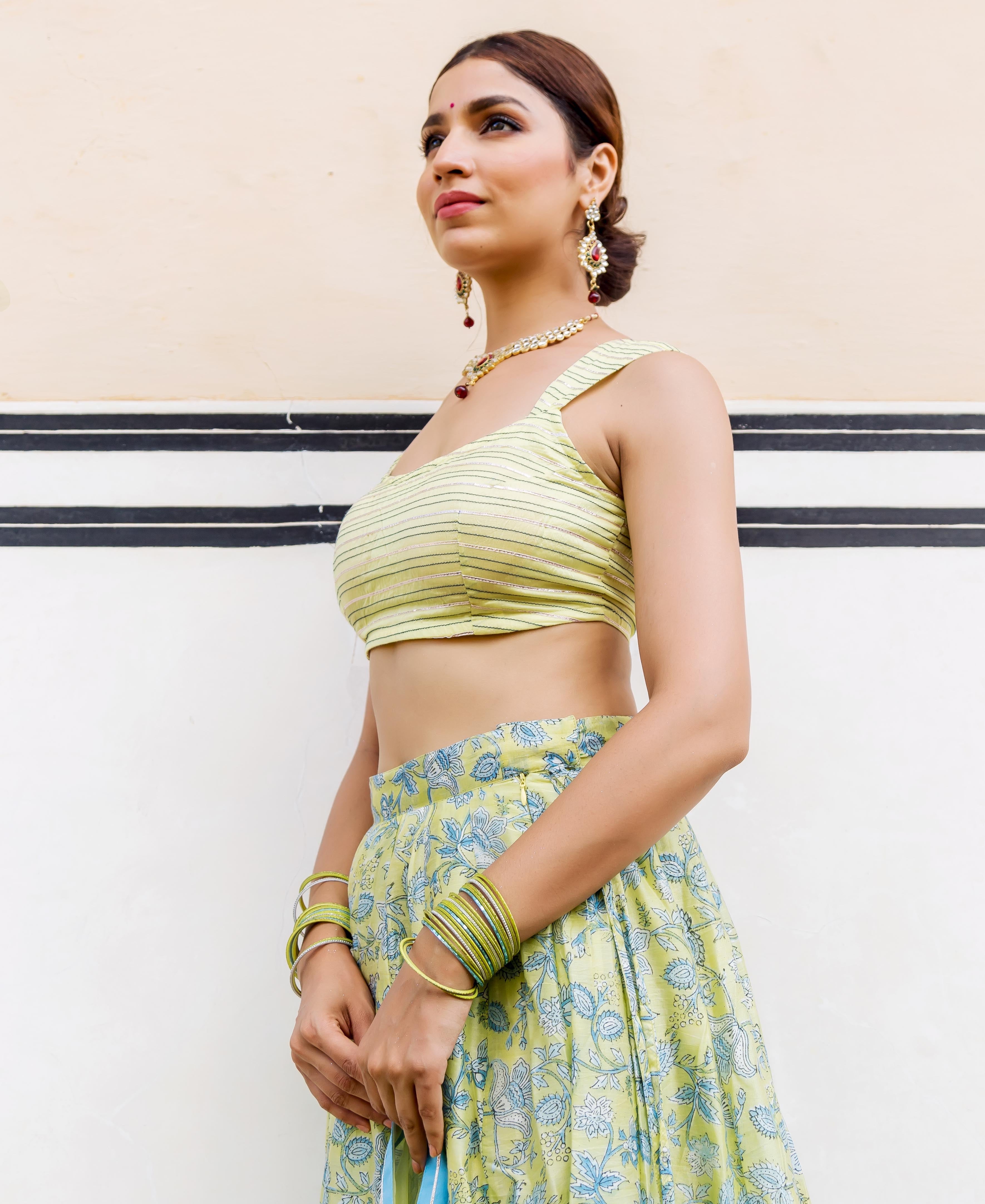 Side view of model in lime green striped crop top and floral hand-block printed lehenga.