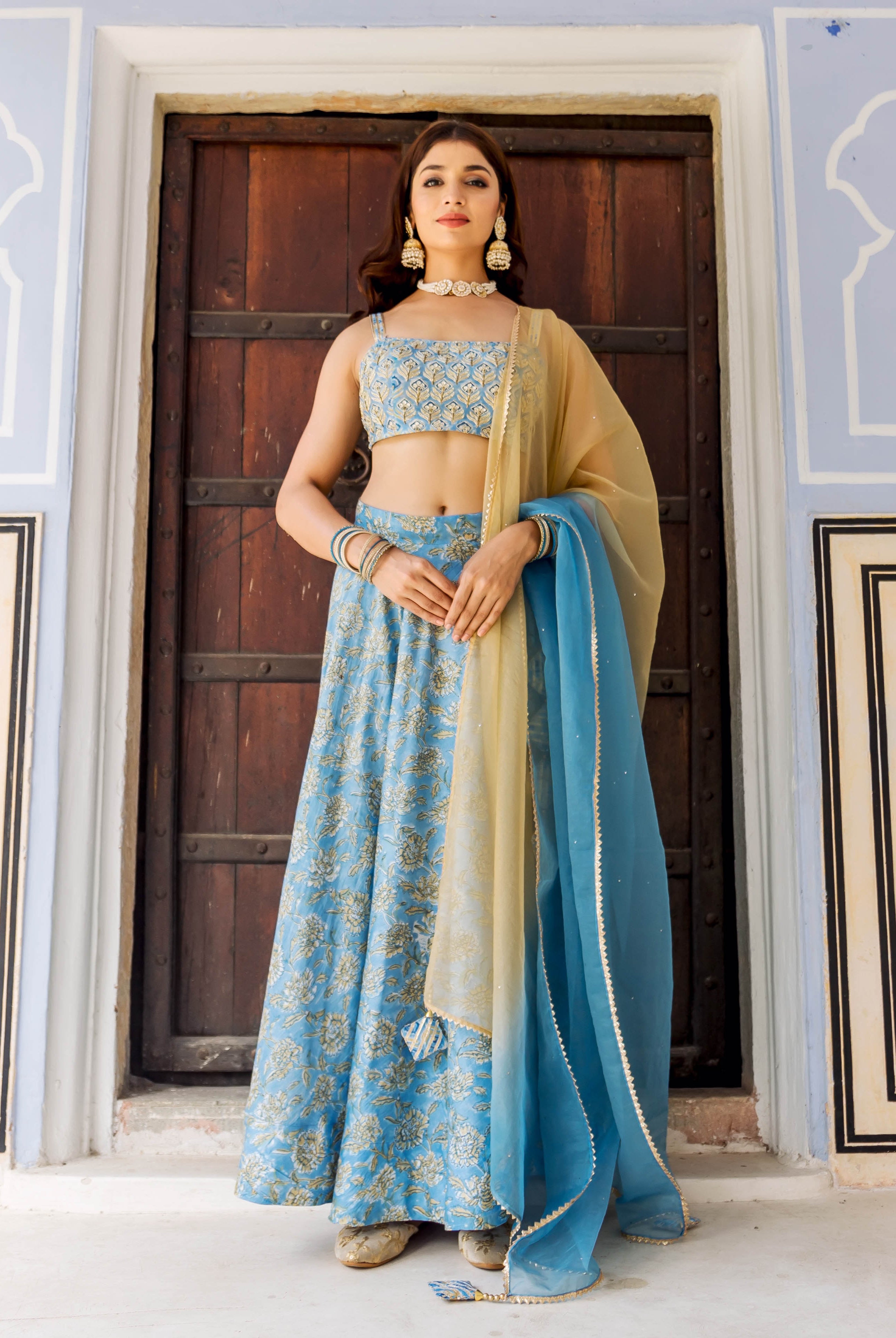 Front full look of model in sky blue hand-block printed and embroidered lehenga set.