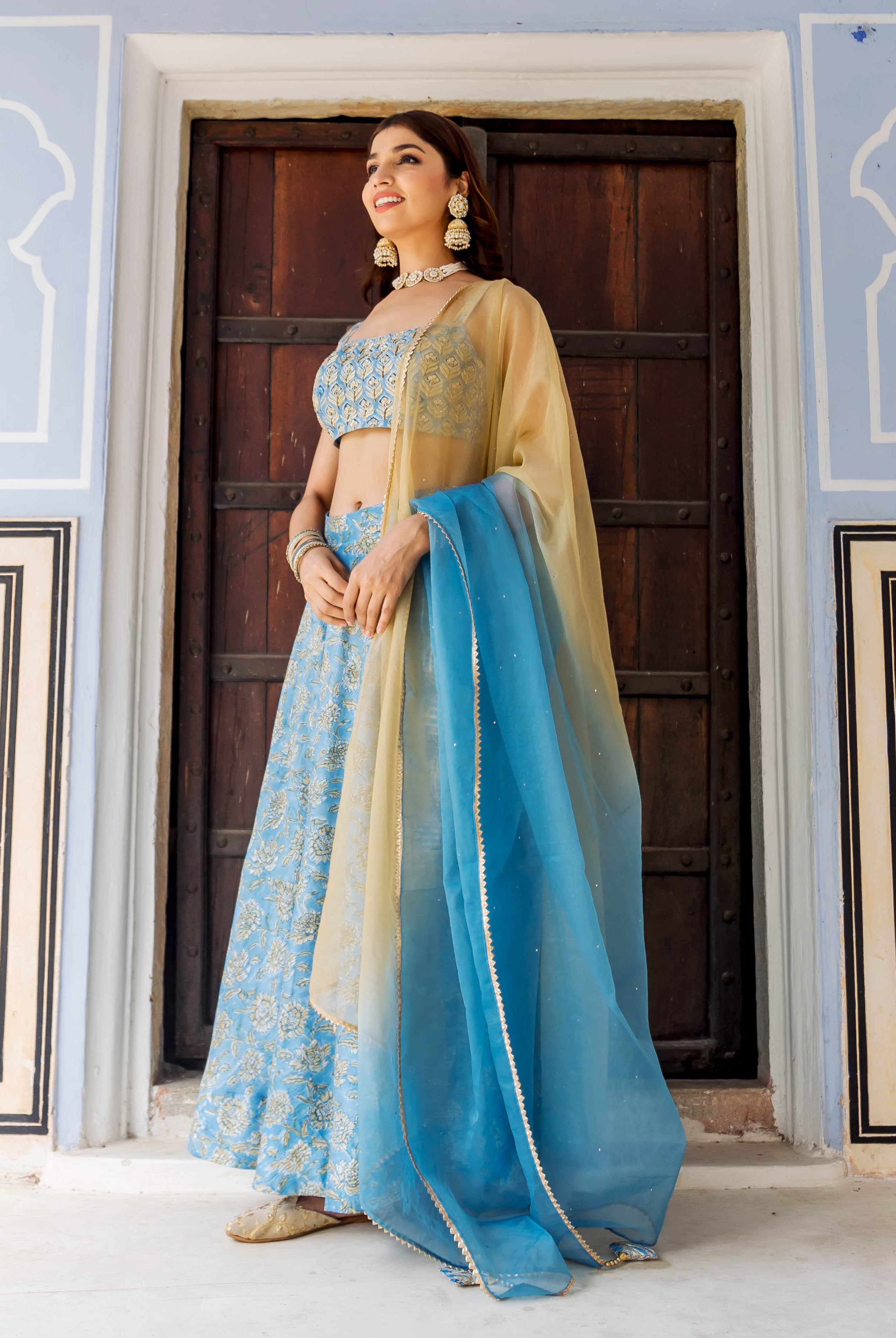 Model in full light blue hand-block printed lehenga set with a golden and blue dupatta.