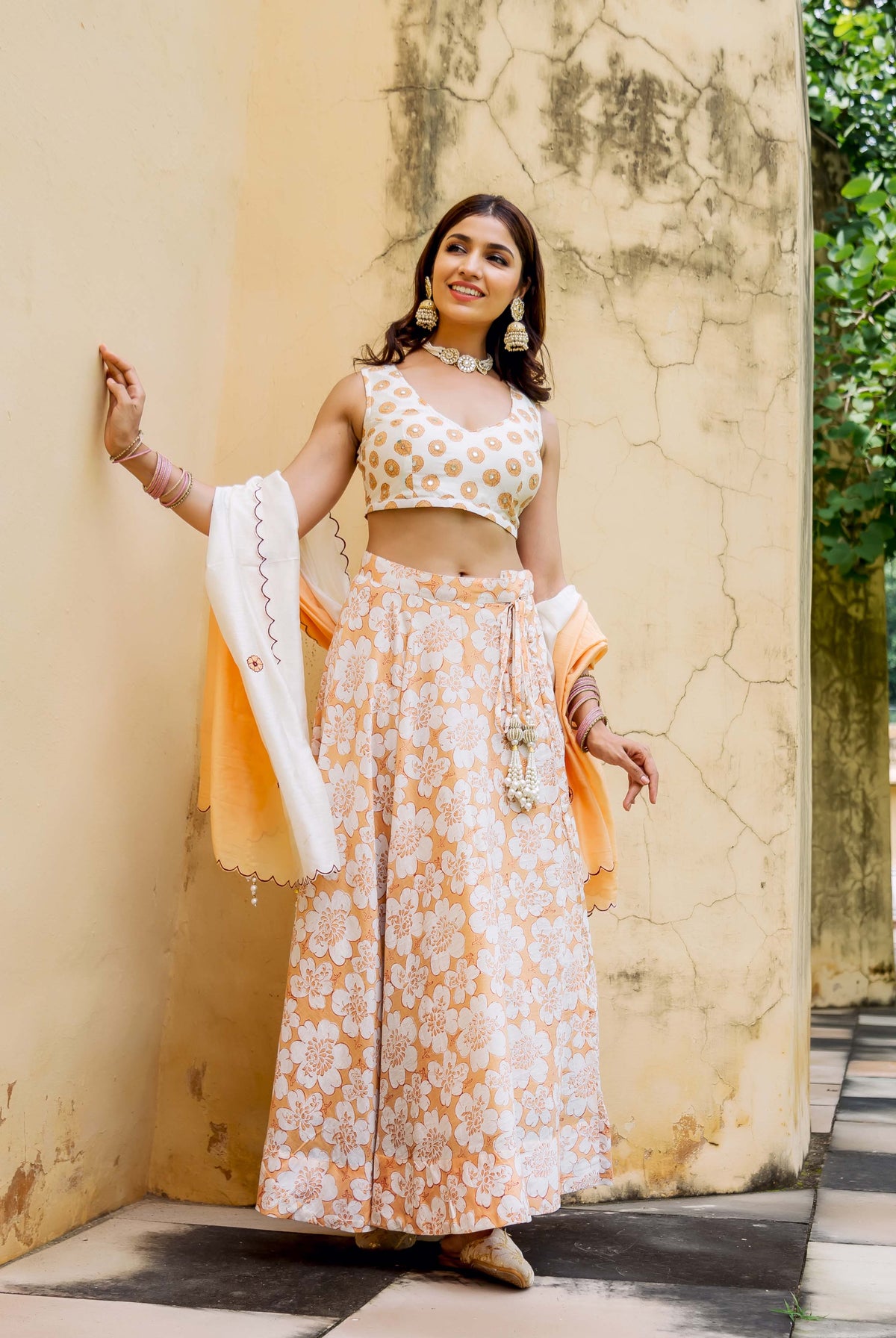 Model wears off-white and peach block printed and embroidered lehenga set.