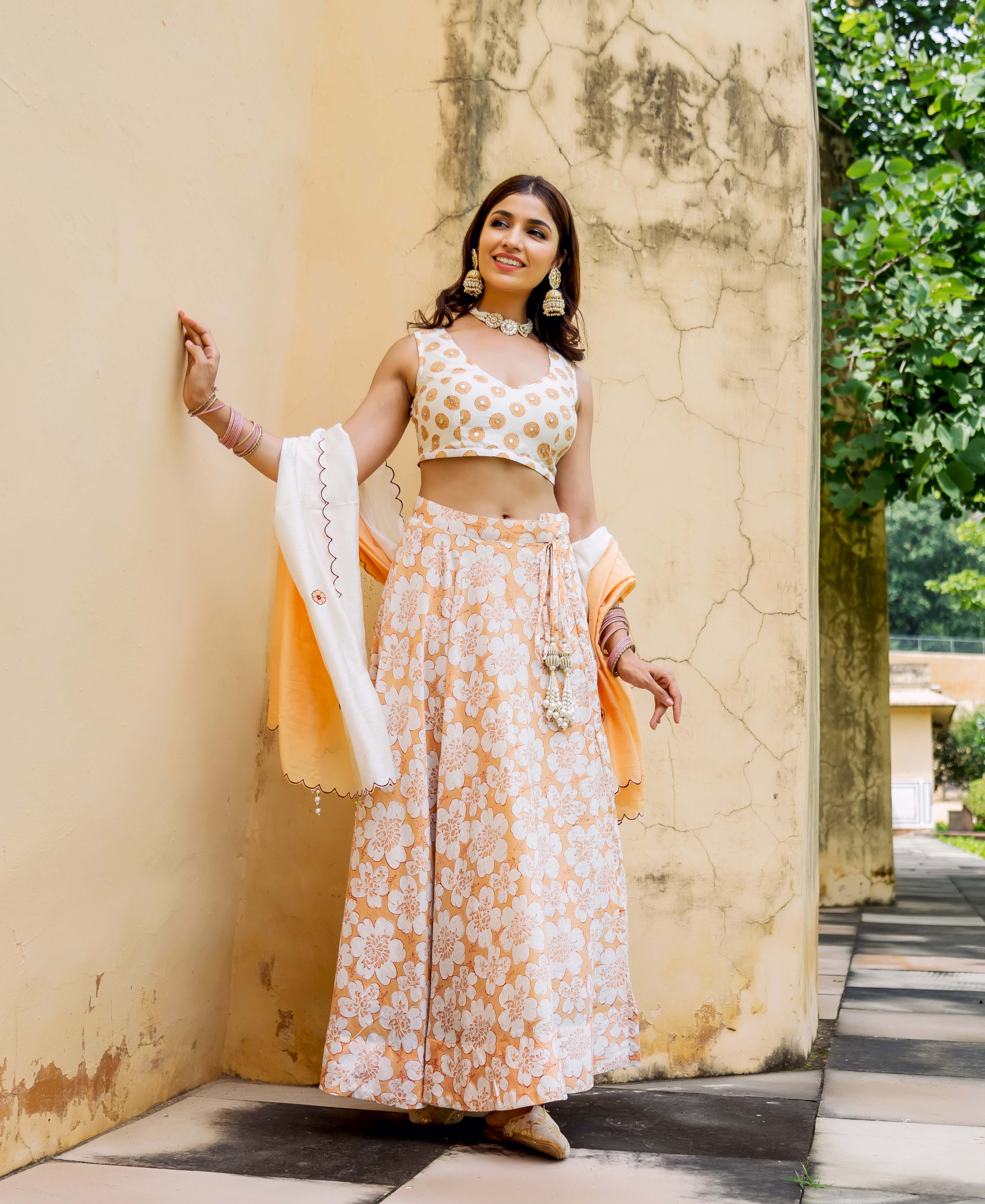 Model wears off-white and peach block printed and embroidered lehenga set.