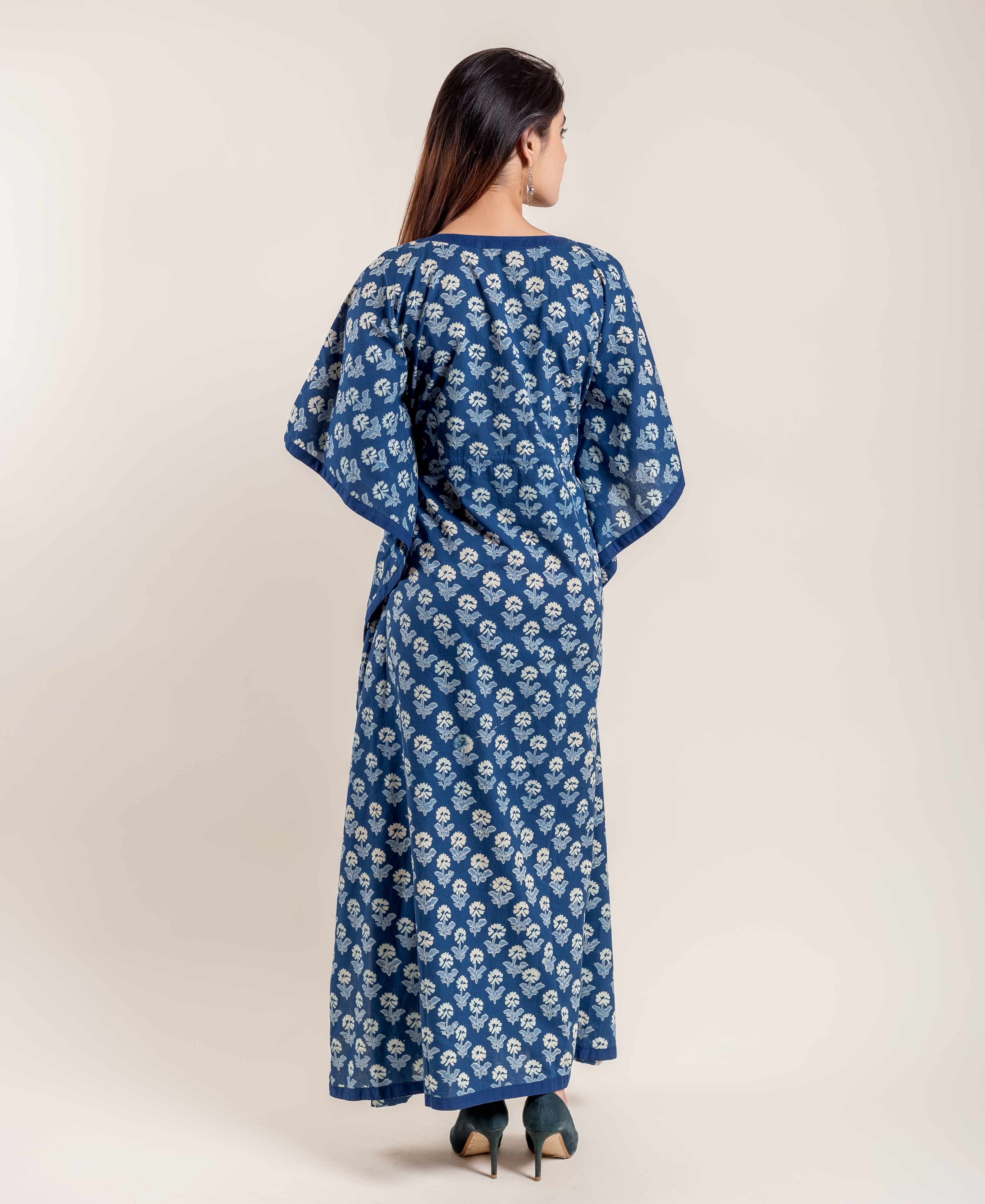 Indigo kaftan with white floral pattern, on model from behind, dark shoes.