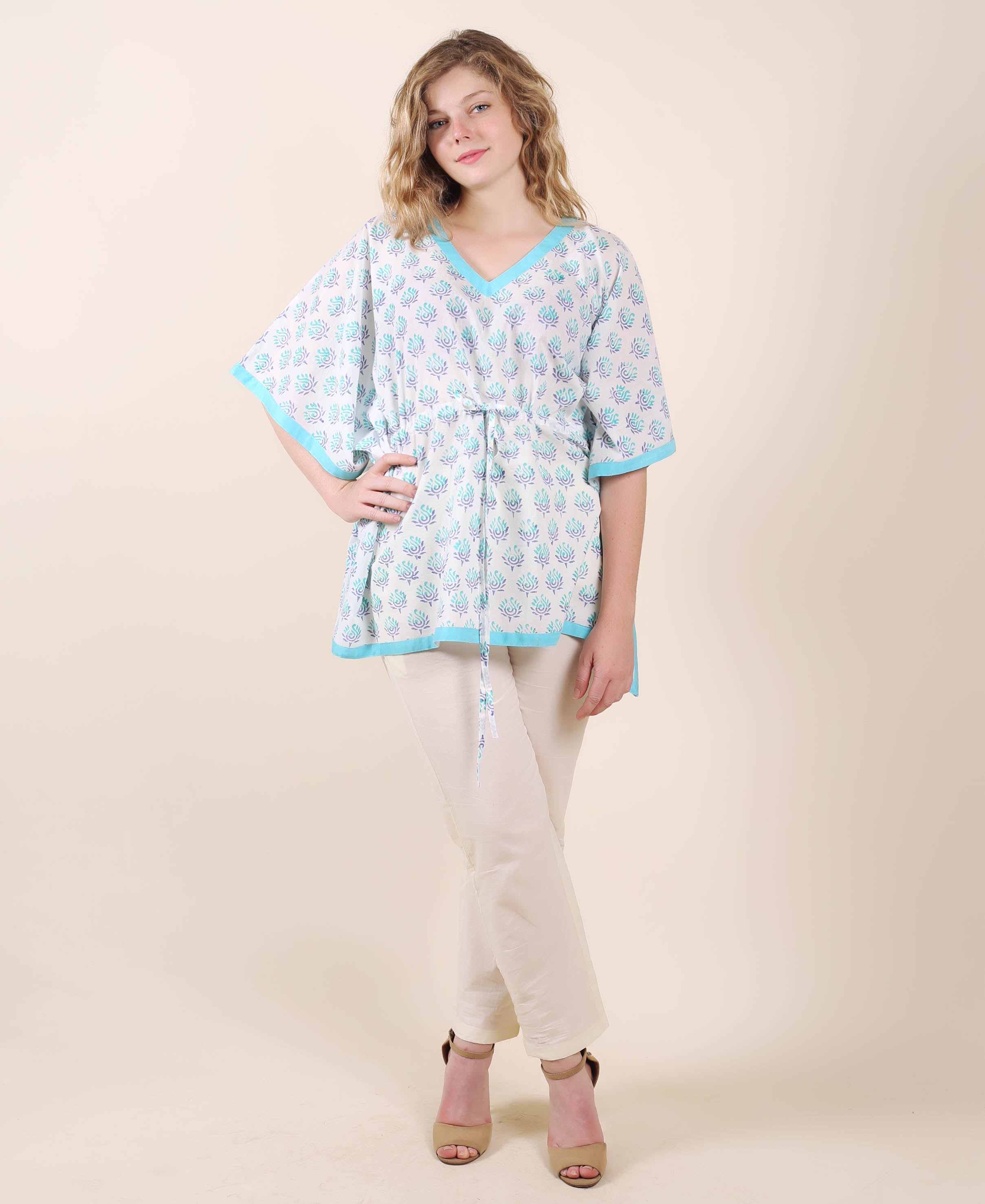 Front full look model in aqua and white ethnic hand-block printed kaftan top and cream trousers.