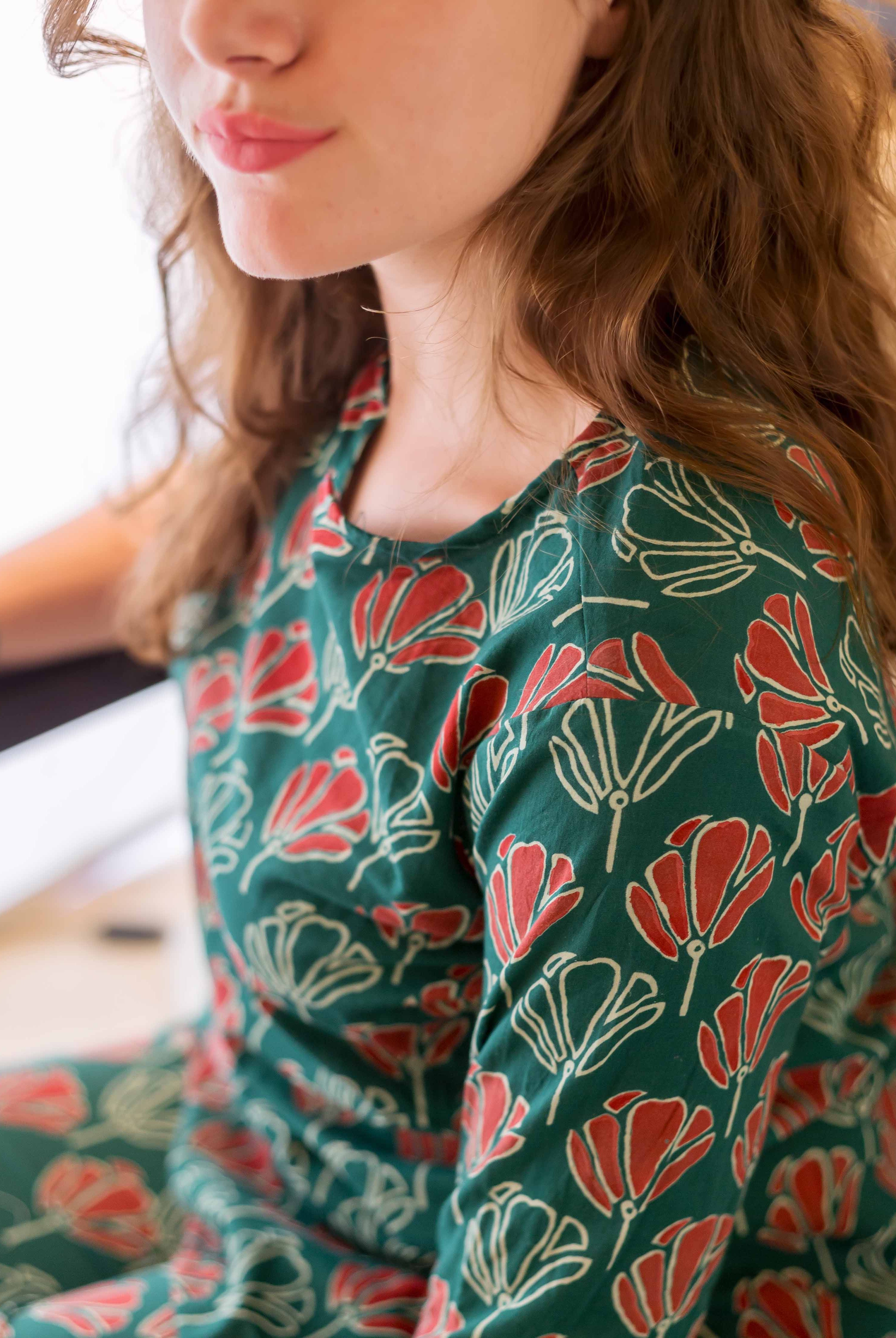 Upper body of model in green and red floral block-printed cotton night suit.