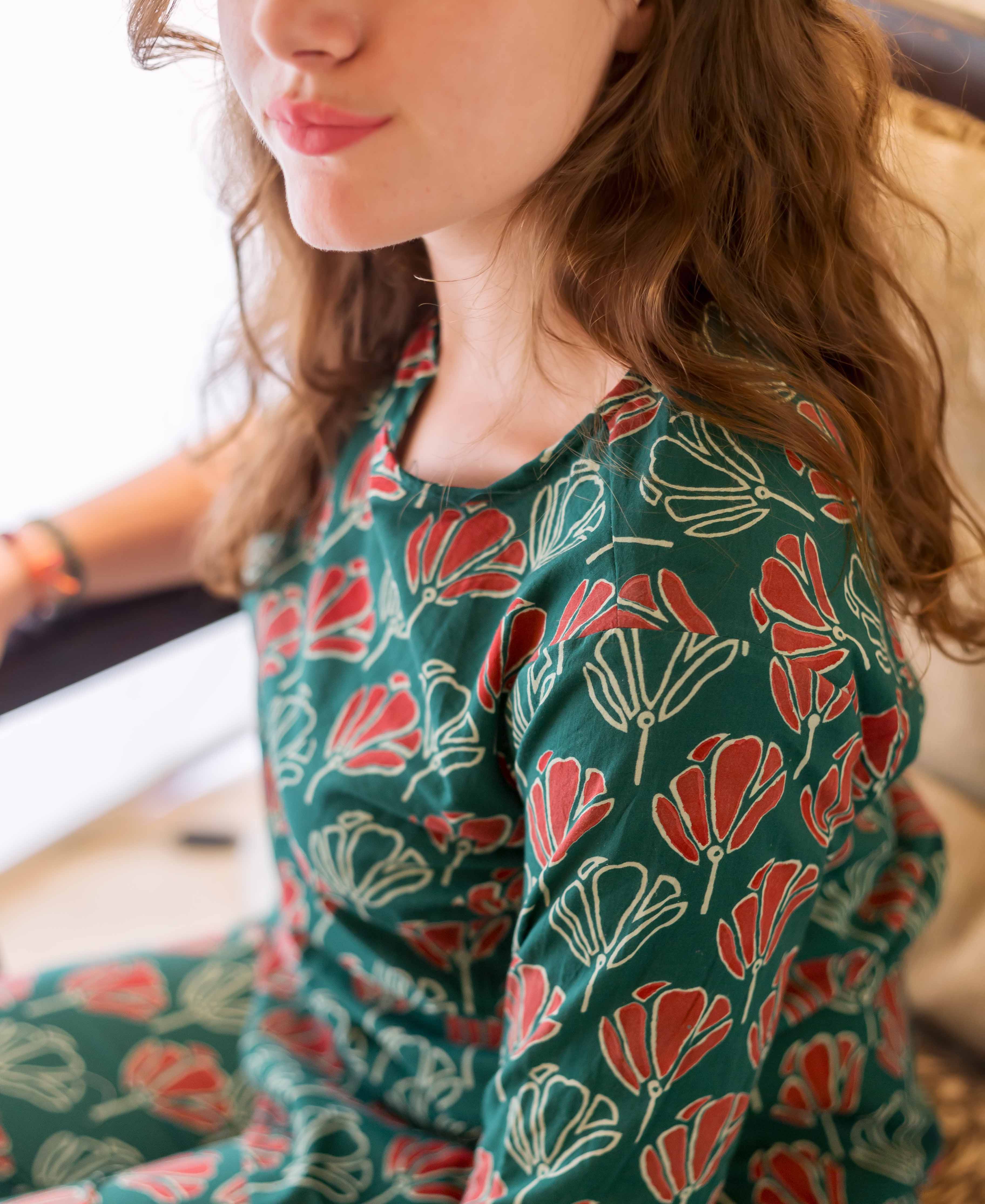 Upper body of model in green and red floral block-printed cotton night suit.