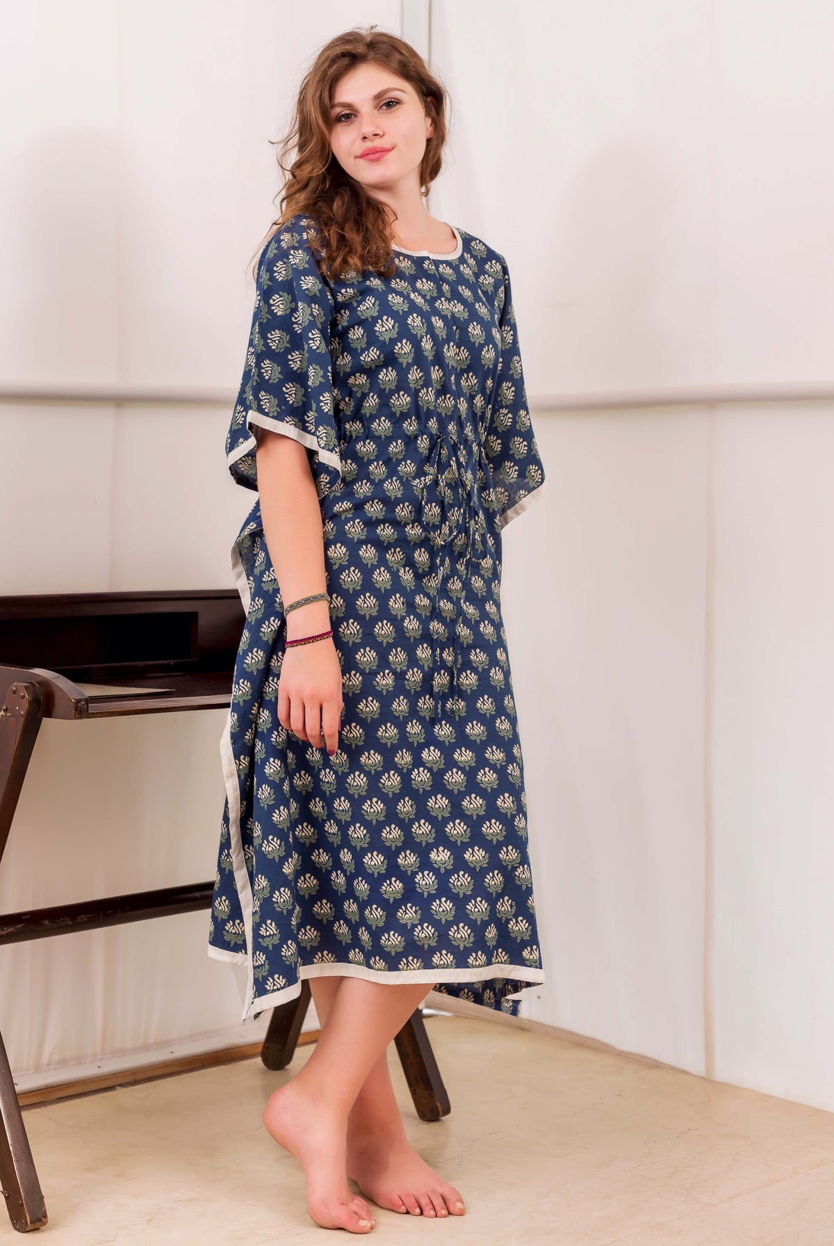 A woman wearing a blue and white block-printed kaftan with a floral pattern.