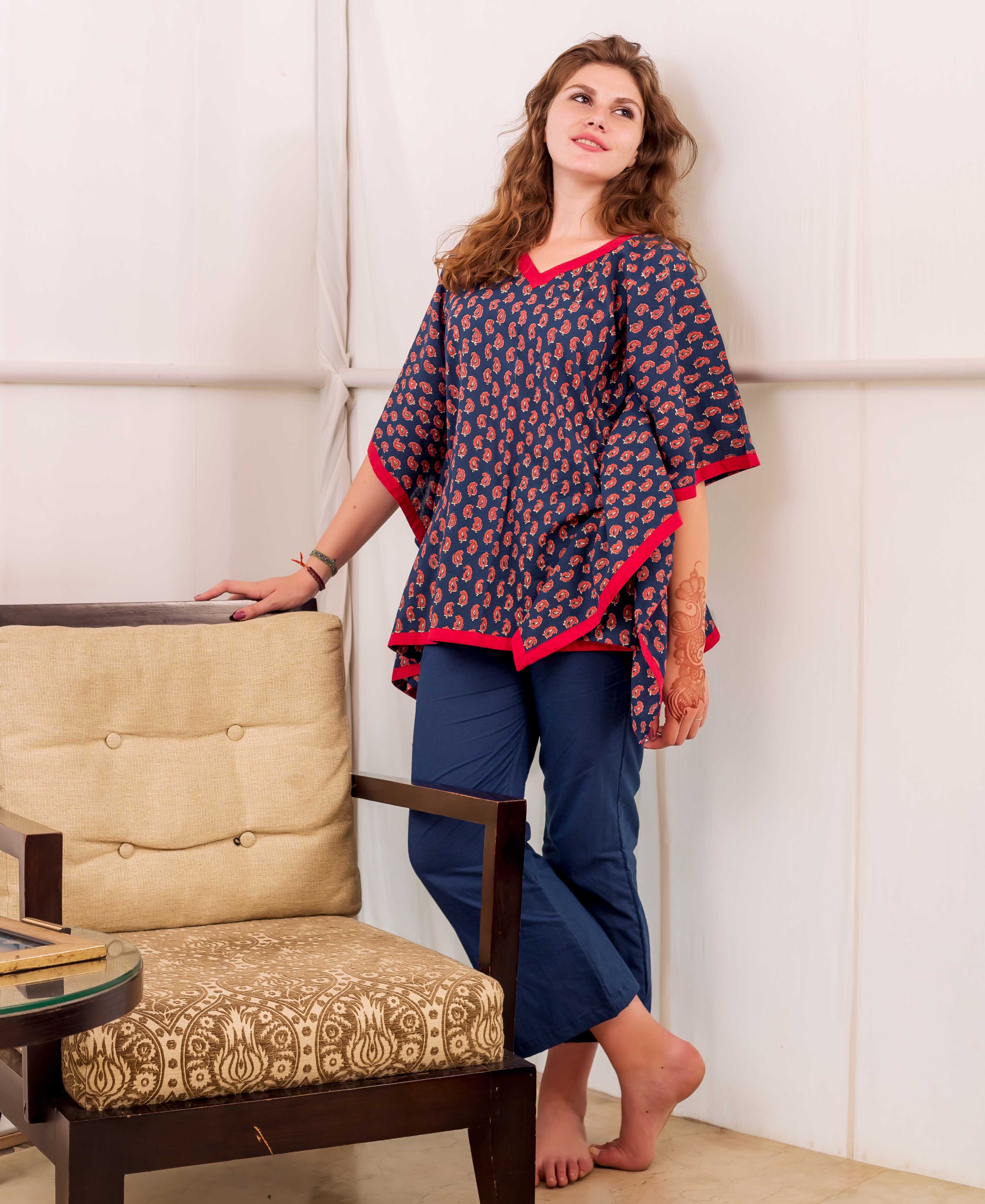 Front view of model wearing an indigo and red paisley print kaftan top with solid blue pants.