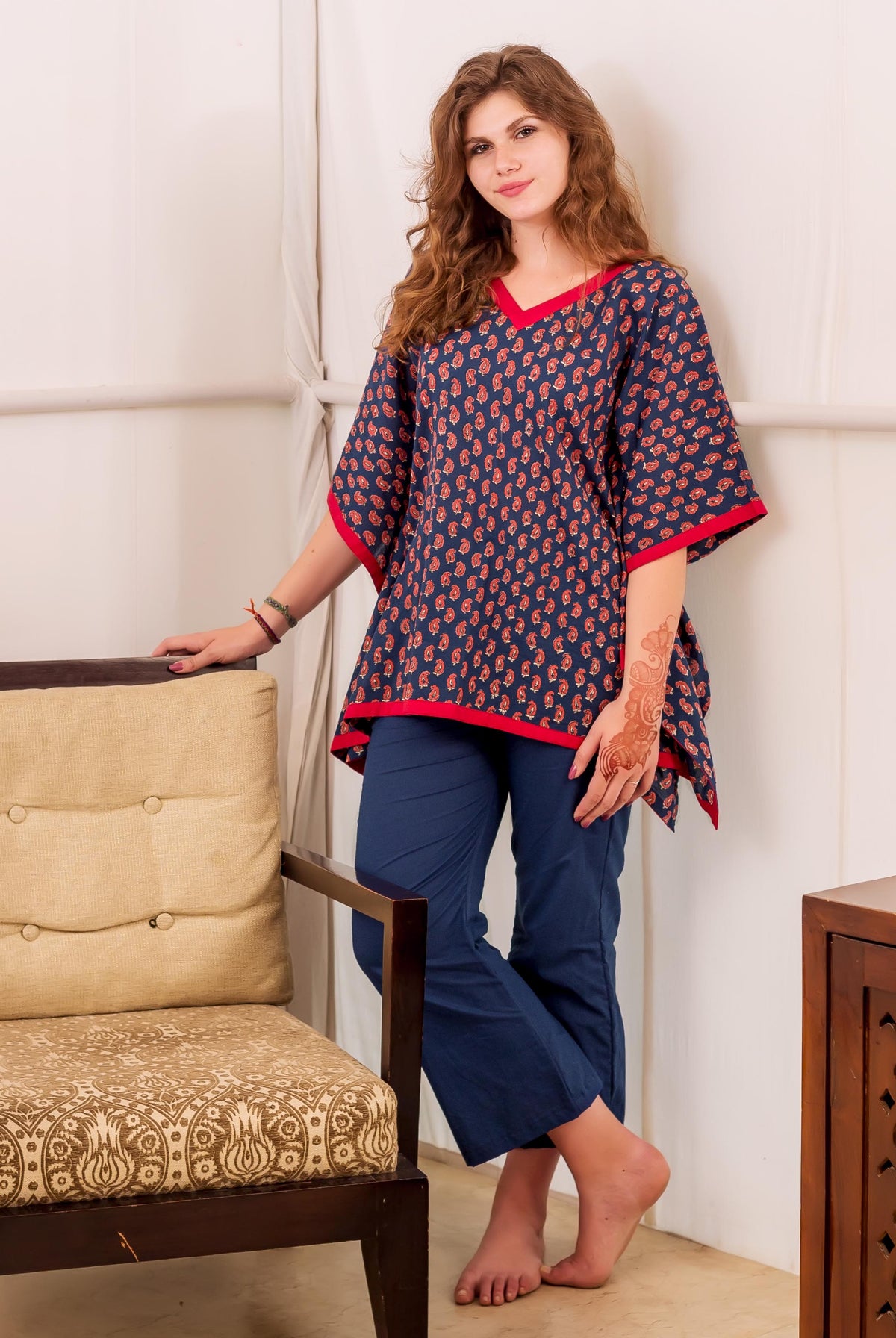Indigo and red hand-block-printed kaftan top on woman, paired with solid blue pants.
