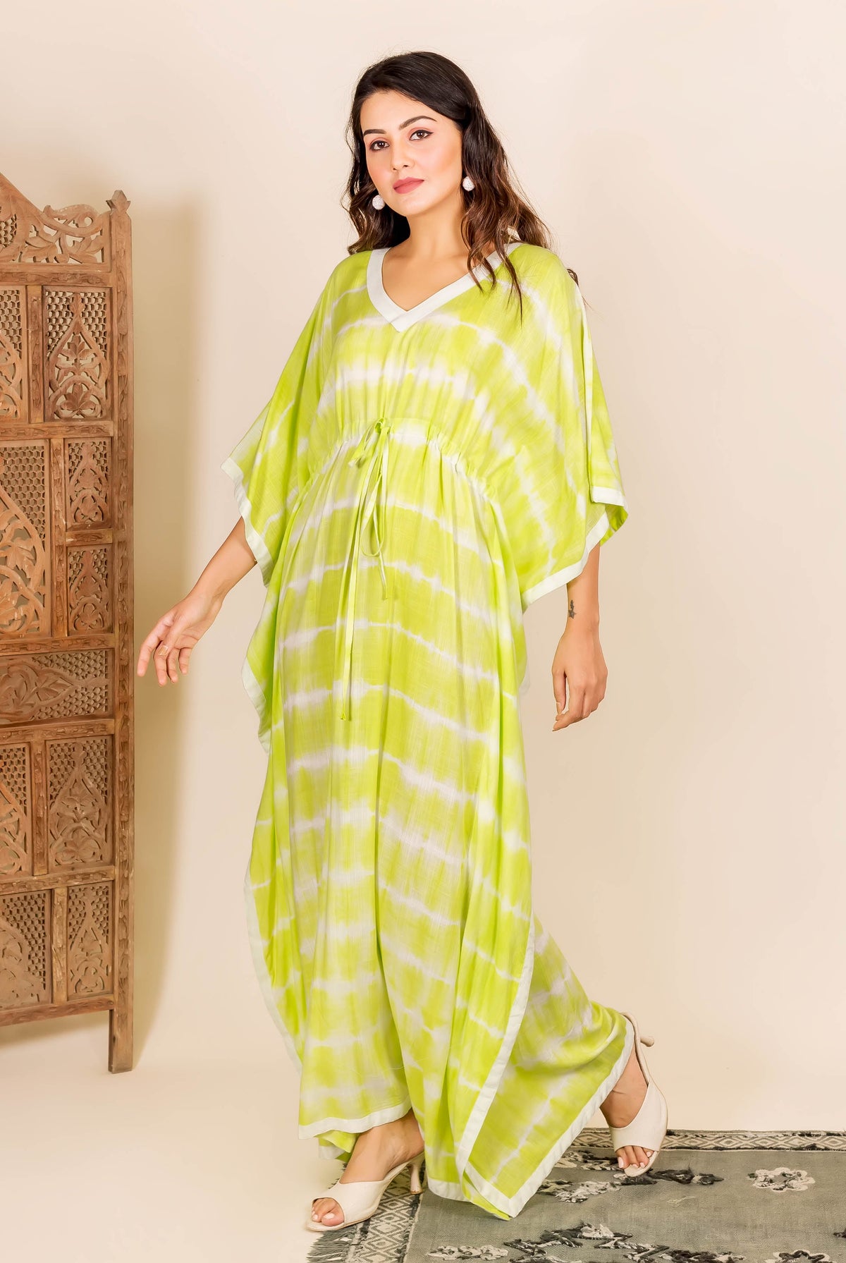 Model wearing a lime and white tie-dye kaftan with an adjustable drawstring waist.