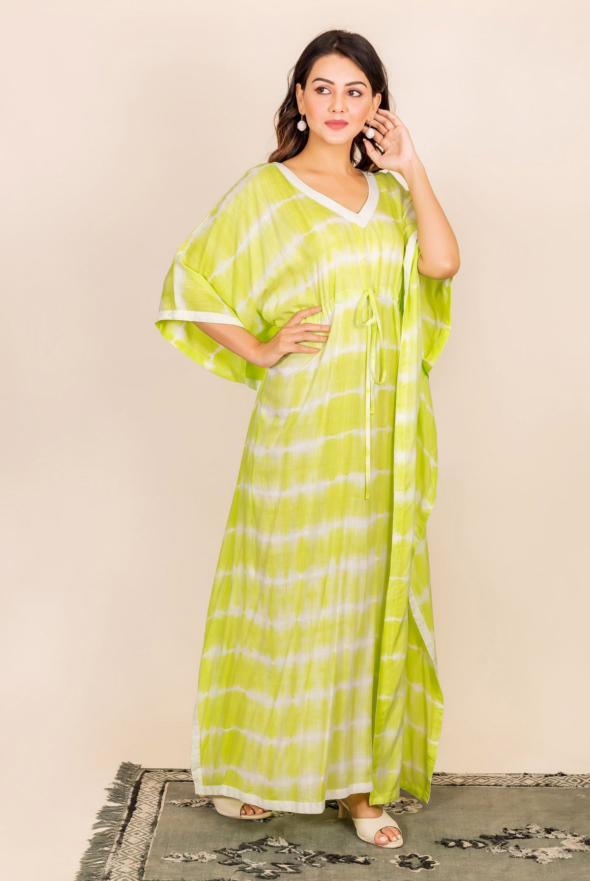 Full-length model in lime and white tie-dye kaftan featuring an adjustable drawstring waist.