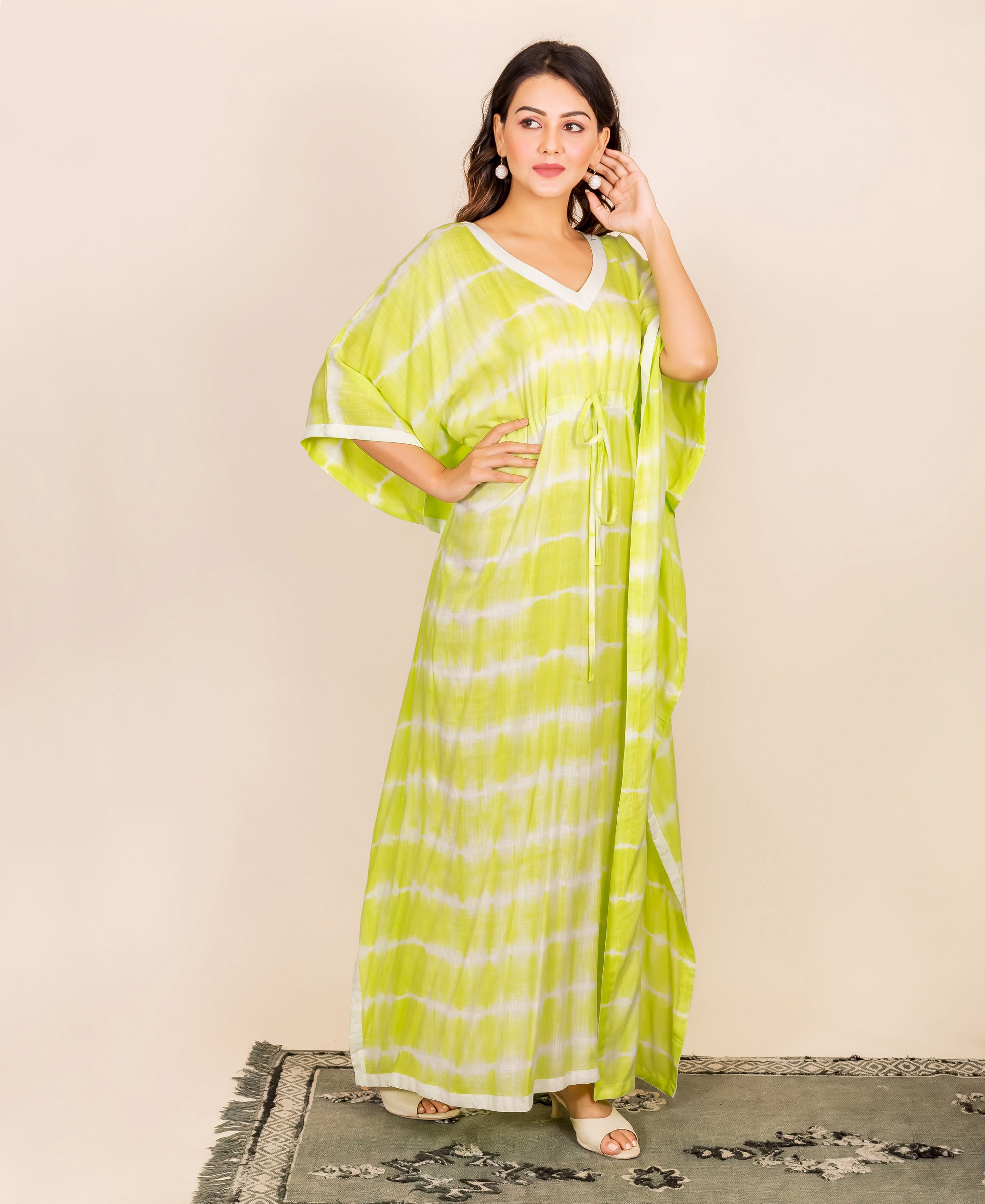 Full-length model in lime and white tie-dye kaftan featuring an adjustable drawstring waist.