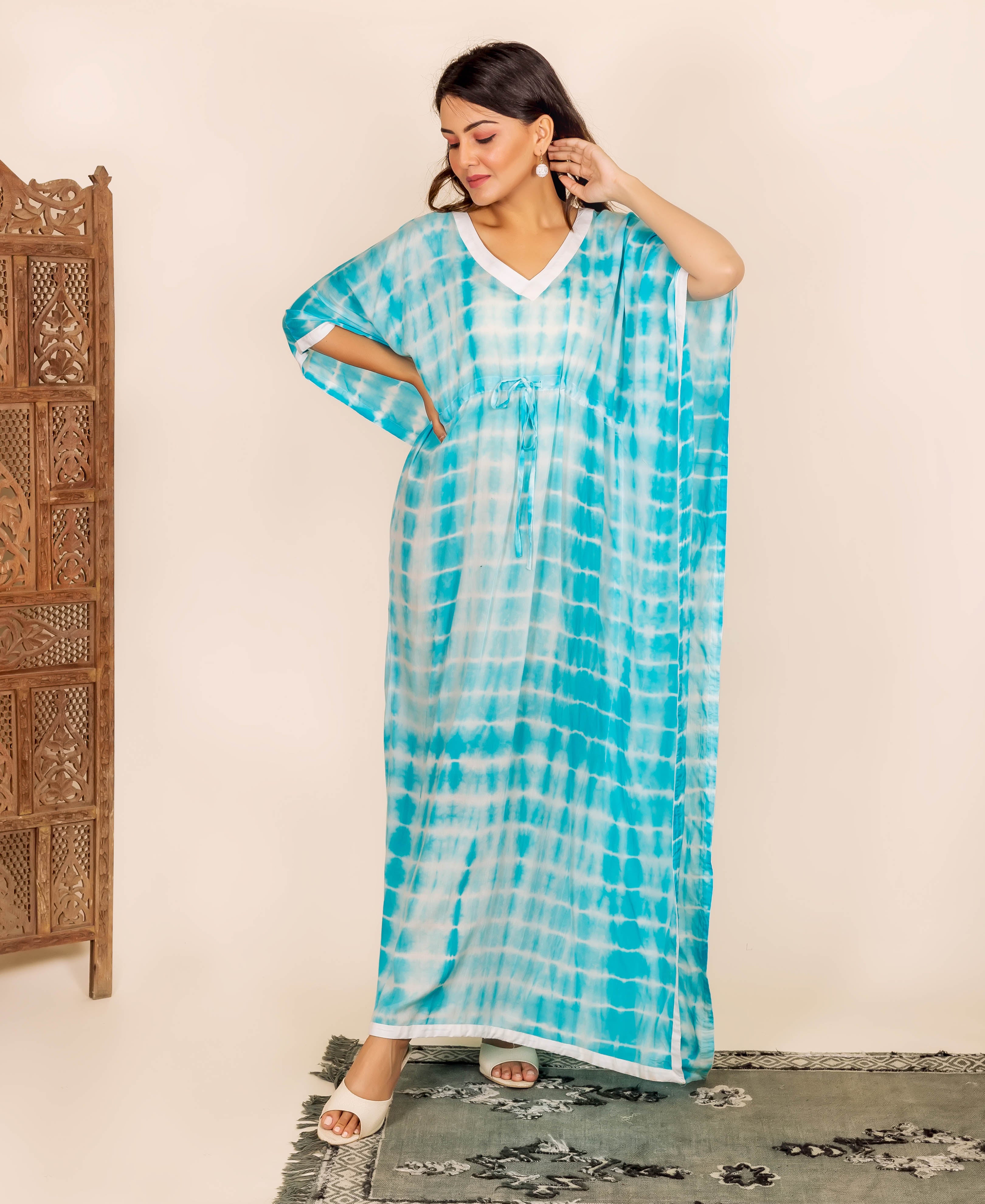 Woman in long blue and white tie-dye kaftan with adjustable waist and white trim.