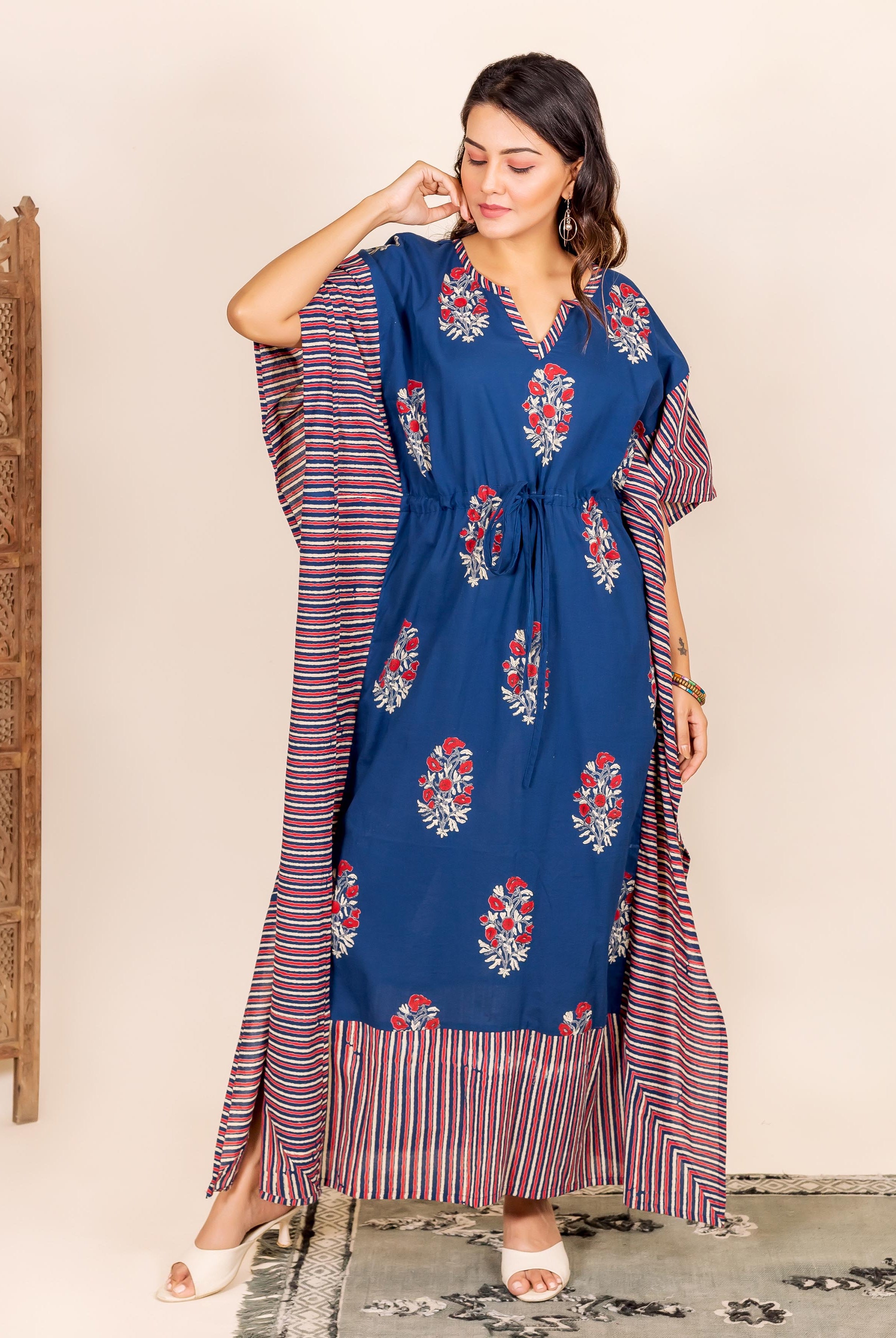 Model in indigo kaftan lounge wear with red floral block print and striped side panels.
