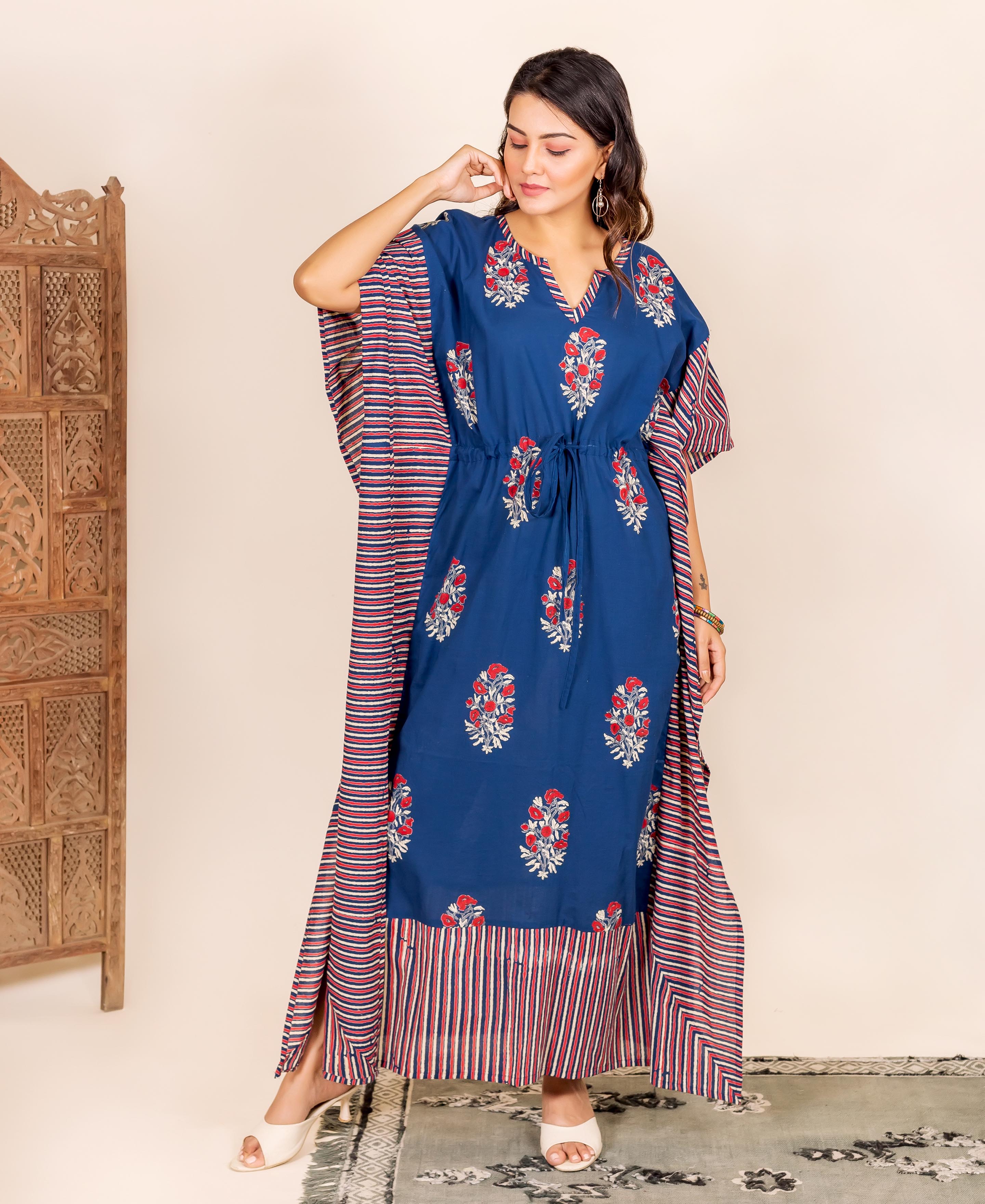 Model in indigo kaftan lounge wear with red floral block print and striped side panels.