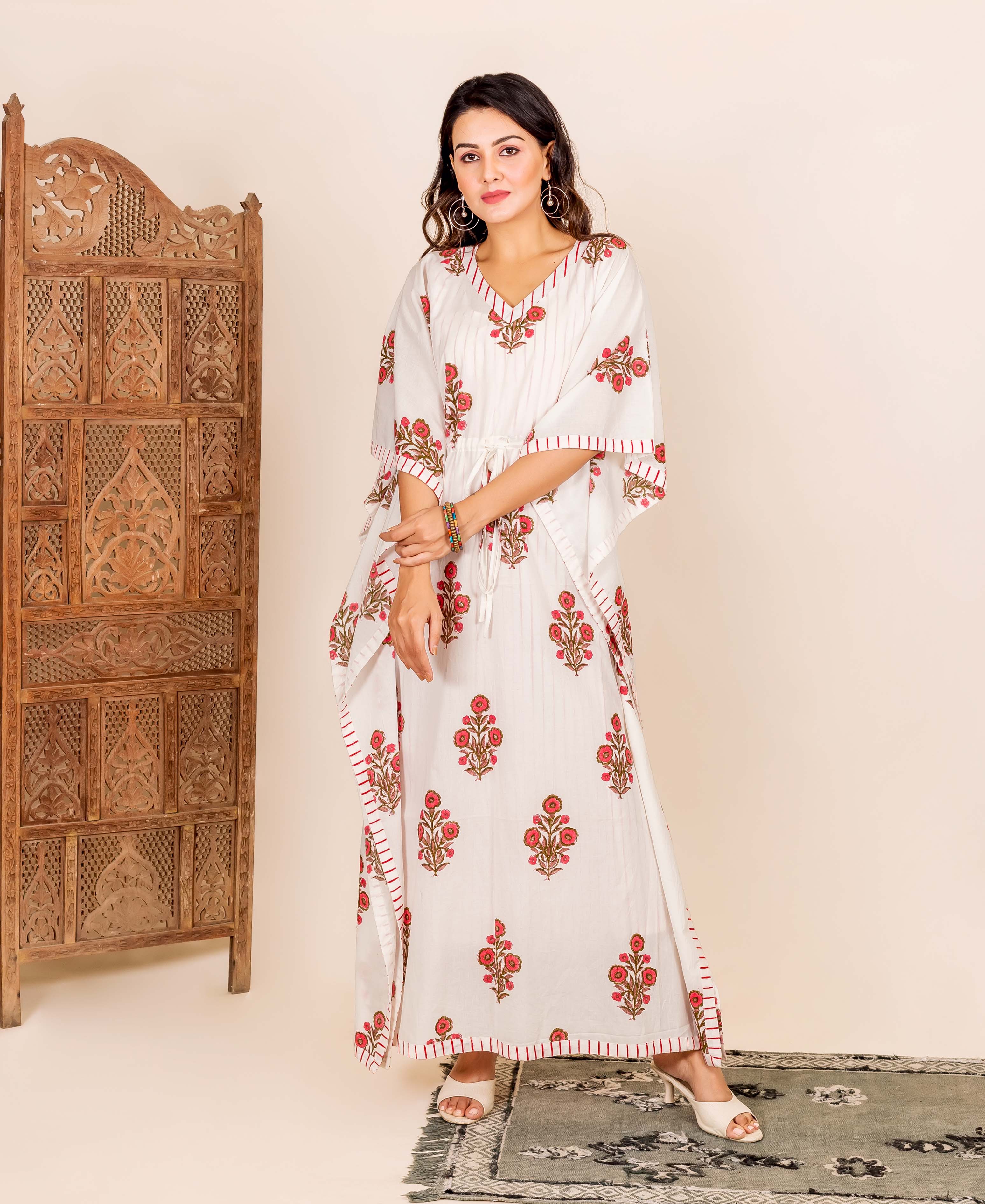 Woman wears white kaftan with red floral block print, V-neck, and drawstring waist.