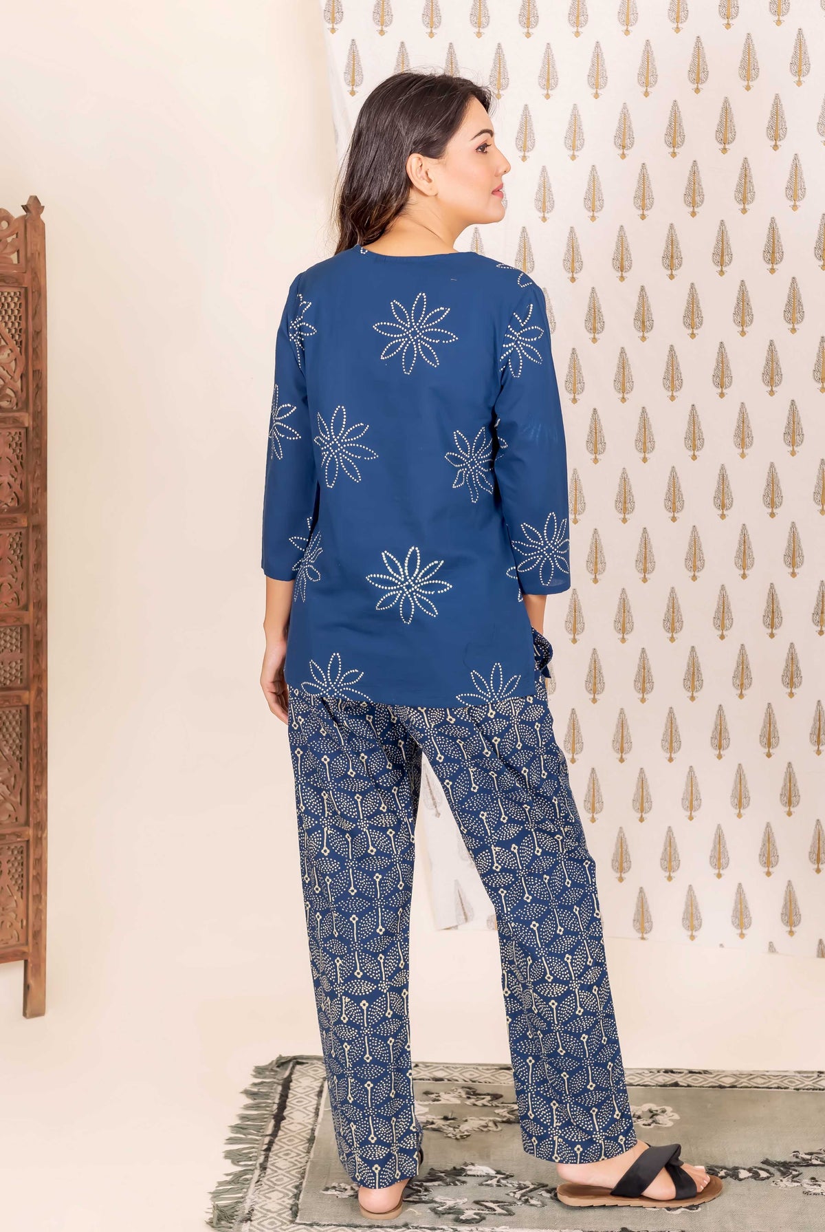 Back shot of model in indigo blue hand-block printed two-piece with floral and geometric designs.