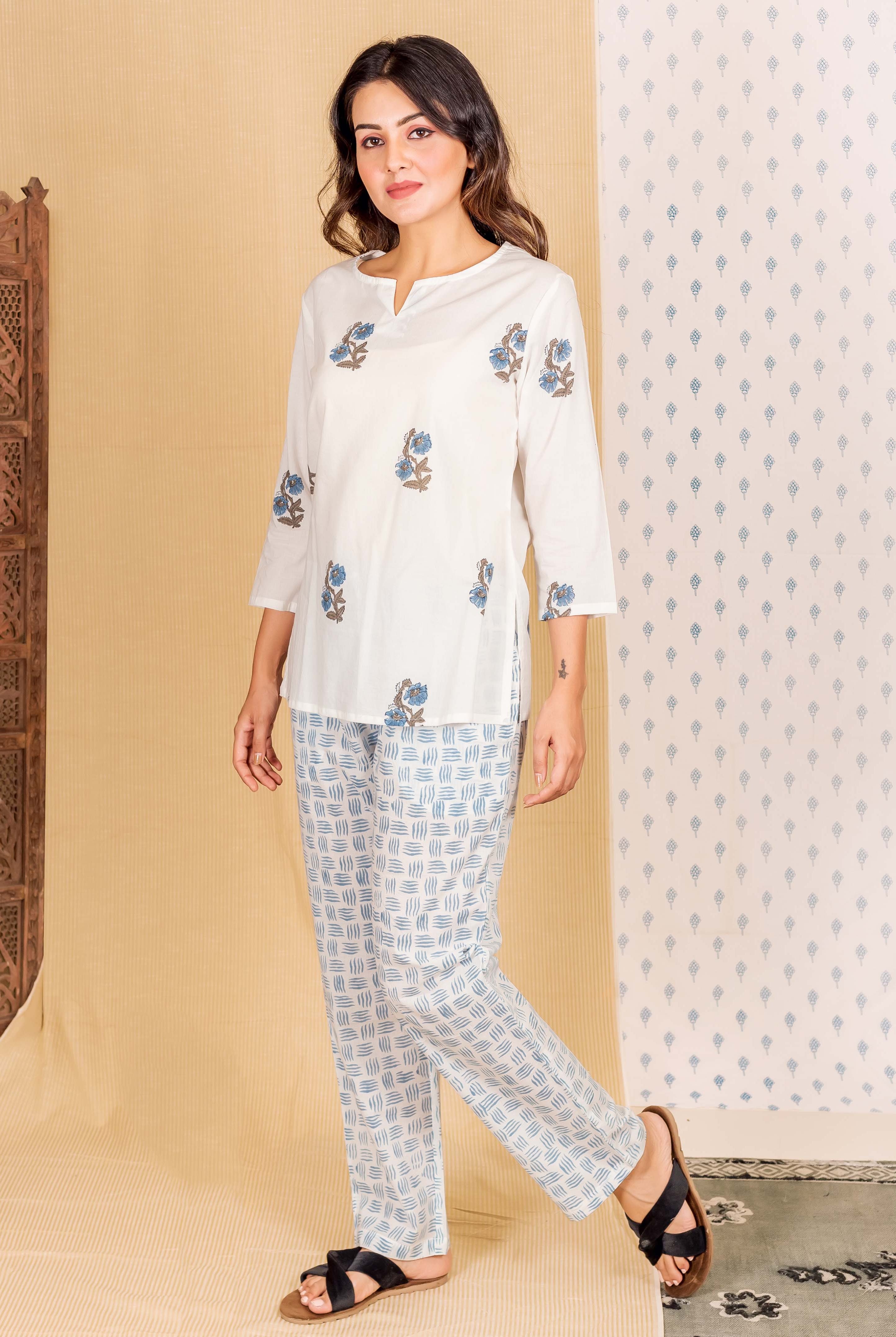 Full look: woman wearing white hand block printed lounge wear with blue floral and geometric patterns.