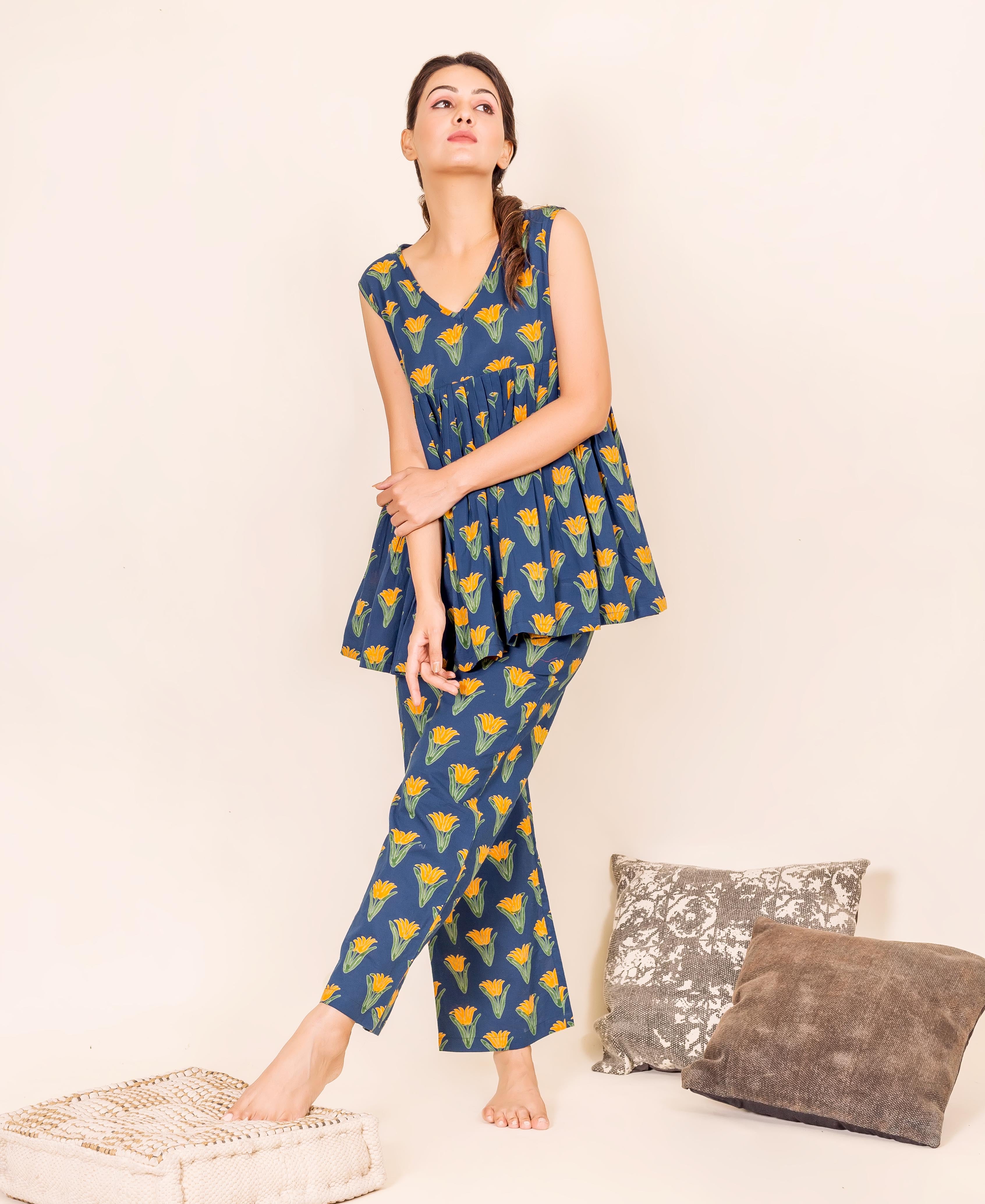 Model in blue sleeveless peplum top and cropped pants with yellow block-printed tulip flowers.