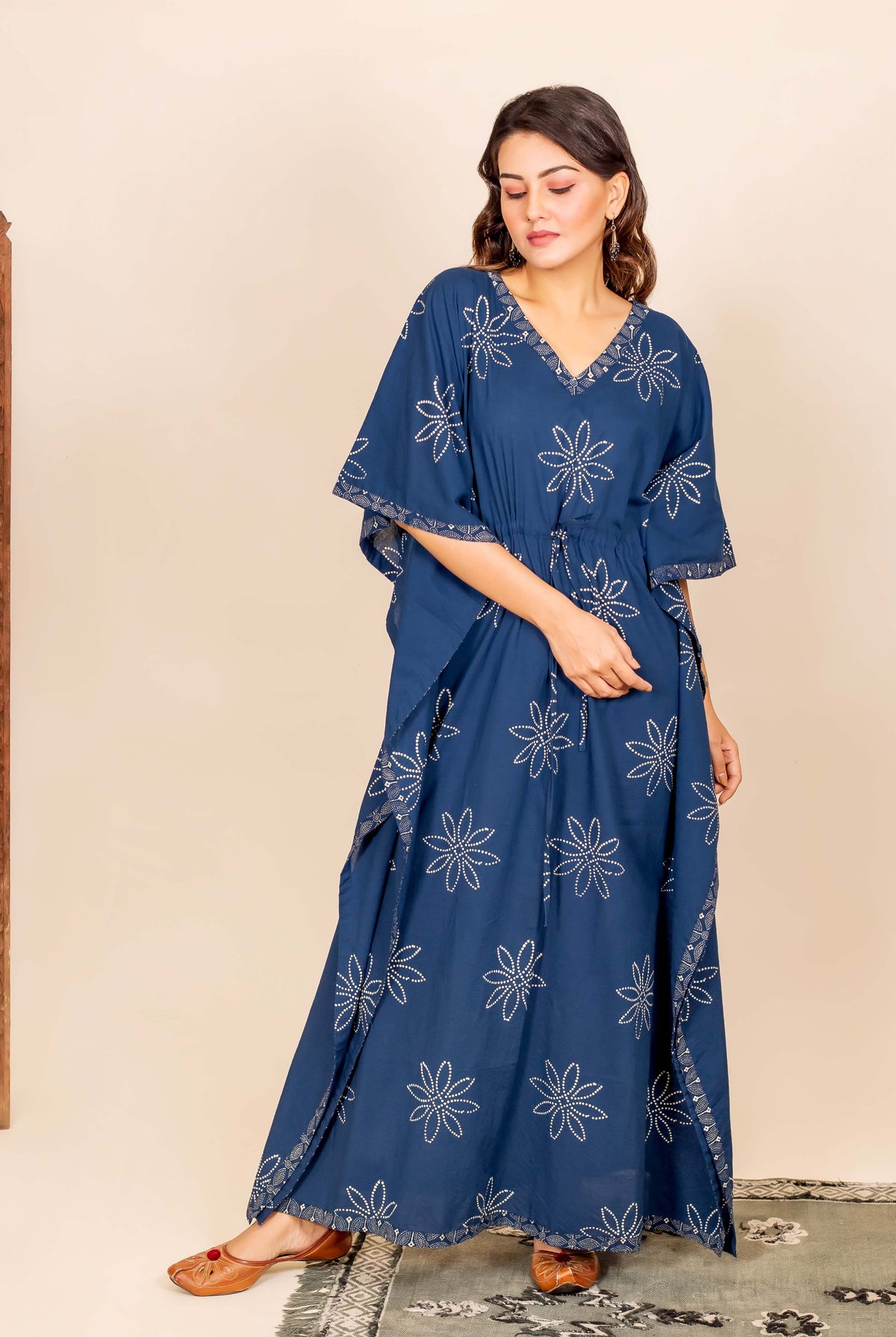 Model wears indigo blue hand block printed kaftan with white star patterns and drawstring waist.