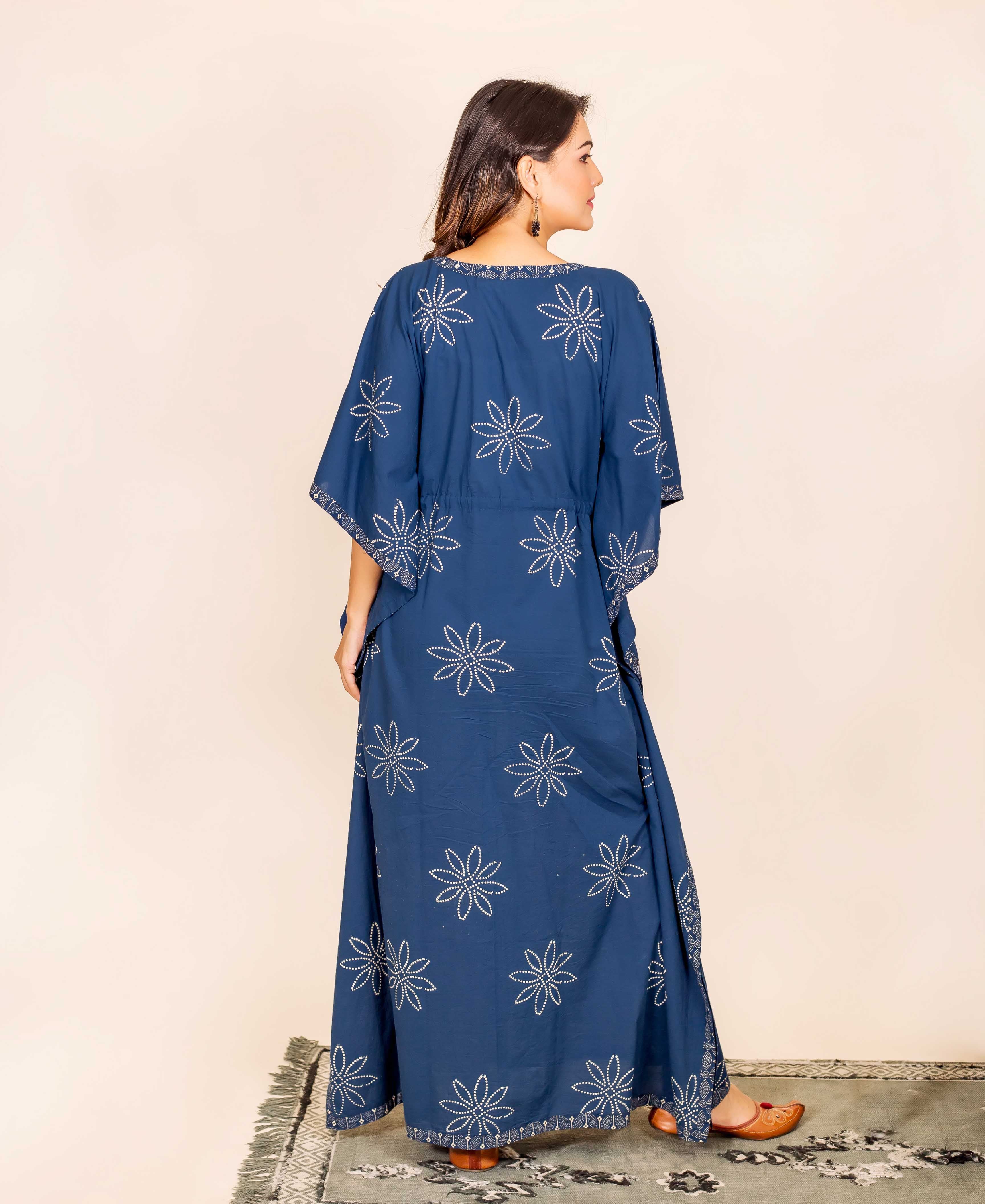 Back view of a model wearing a long indigo kaftan with white block-printed star patterns.