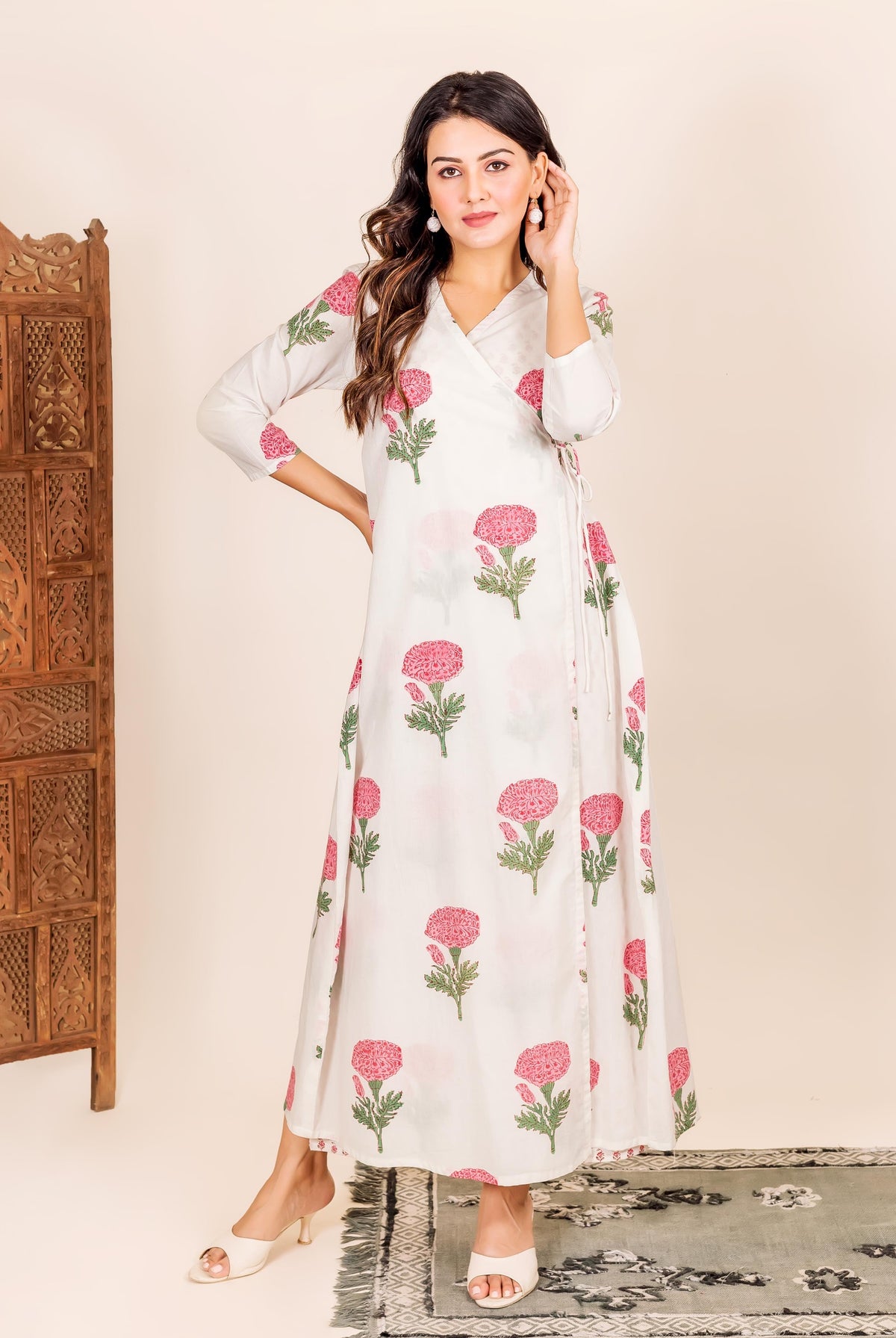 Standing model in a white hand-block-printed wrap dress with bold pink flowers.