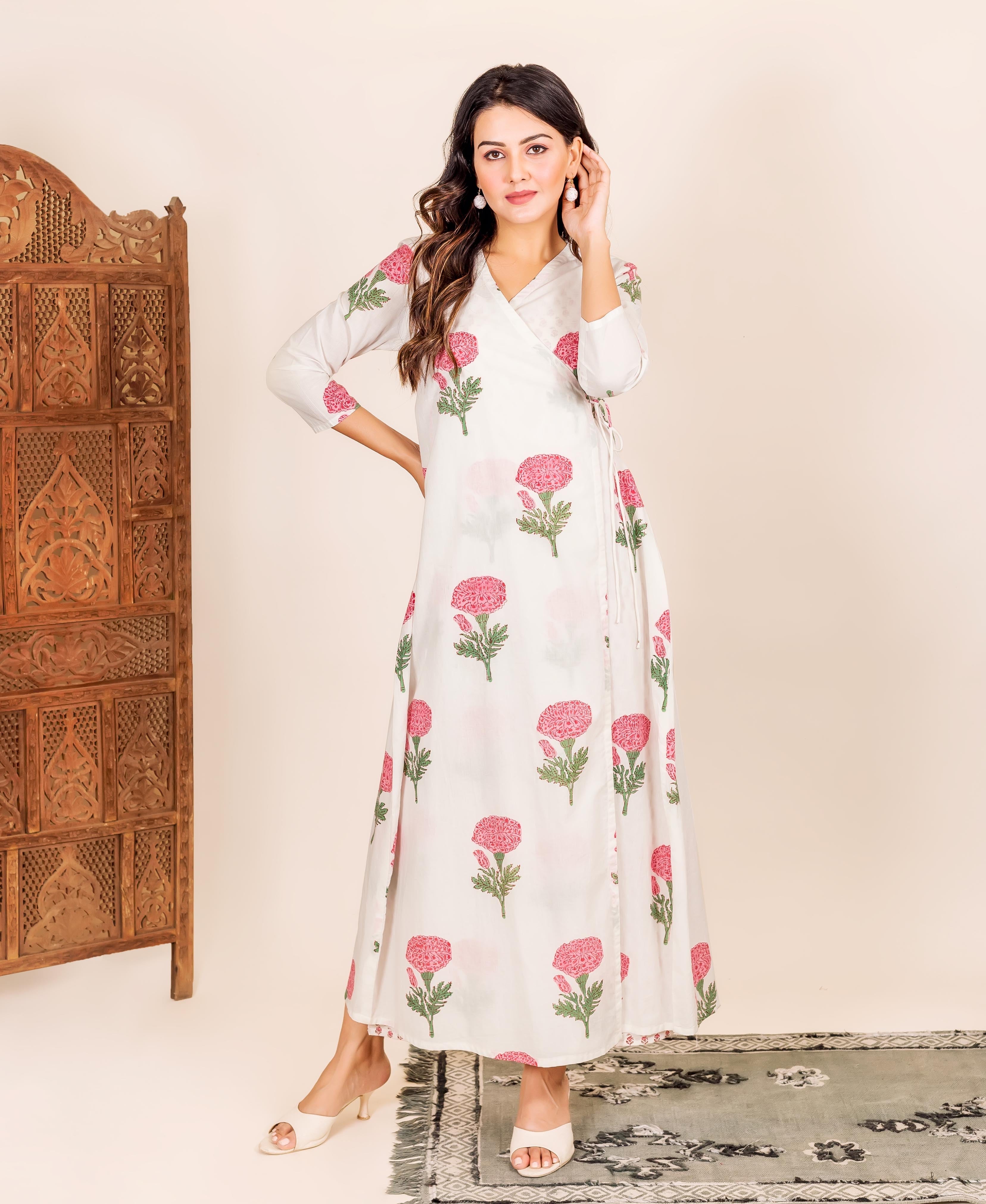 Standing model in a white hand-block-printed wrap dress with bold pink flowers.