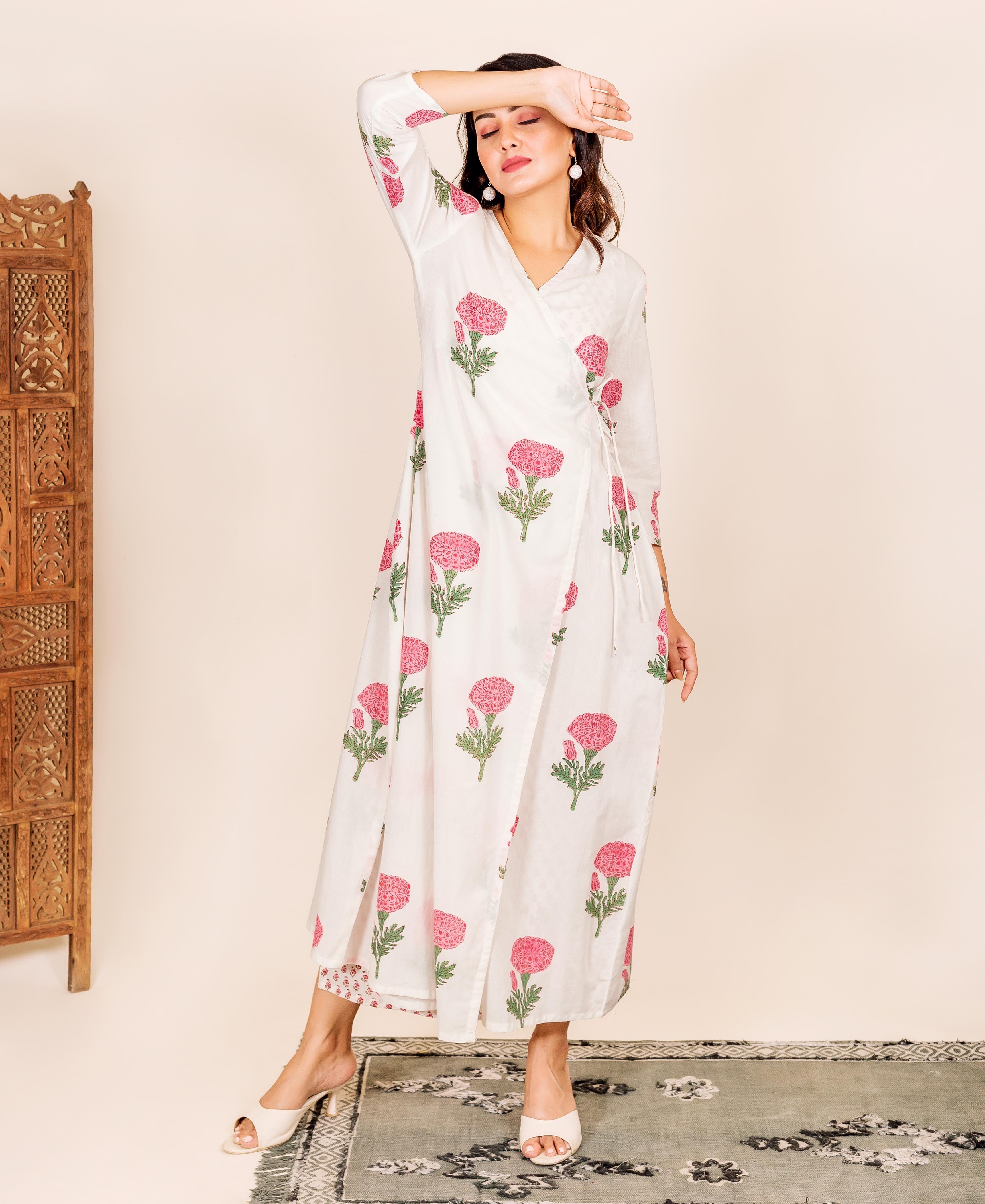 Standing model in a white wrap-style block-printed robe with pink marigold flowers.