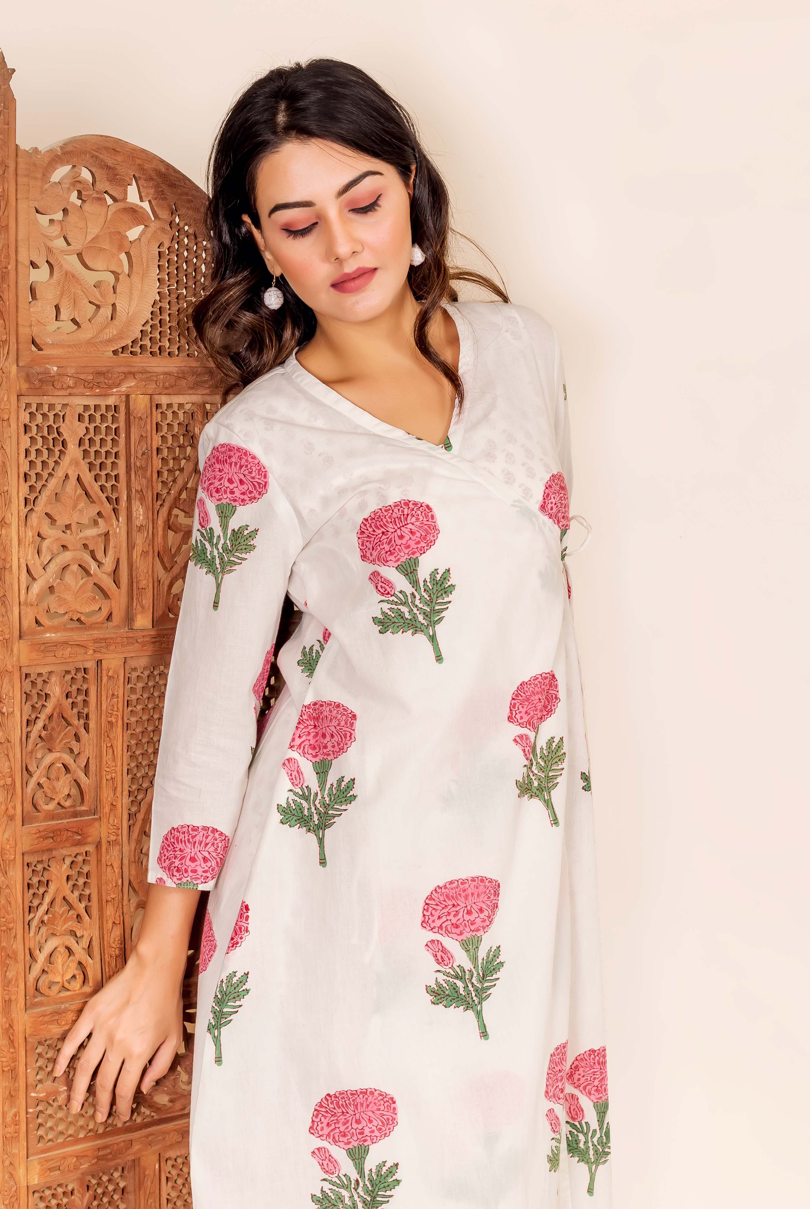 Model in white wrap-around tunic with pink marigold hand-block prints.