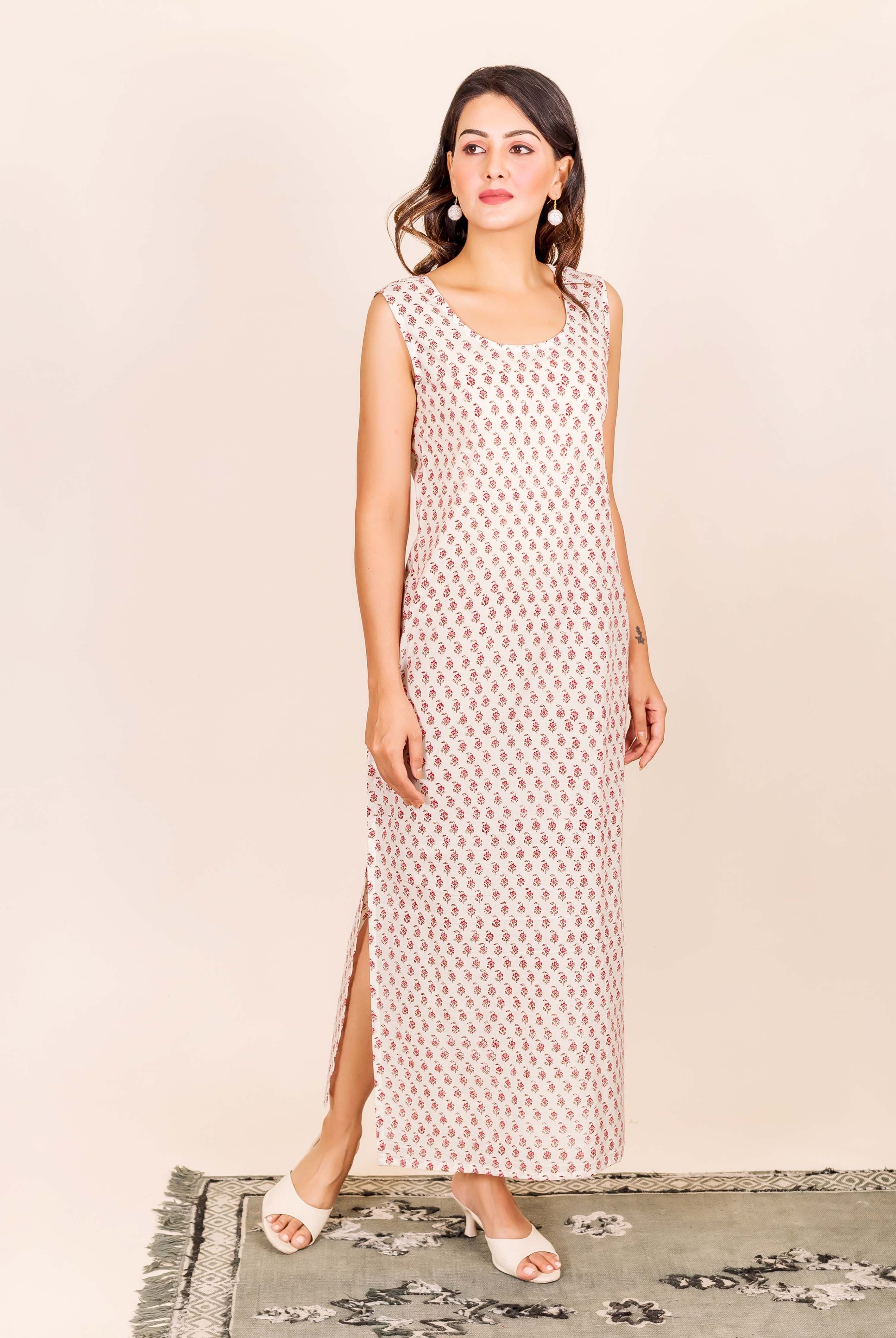 Model in an off-white sleeveless maxi dress with small red hand-block floral print.