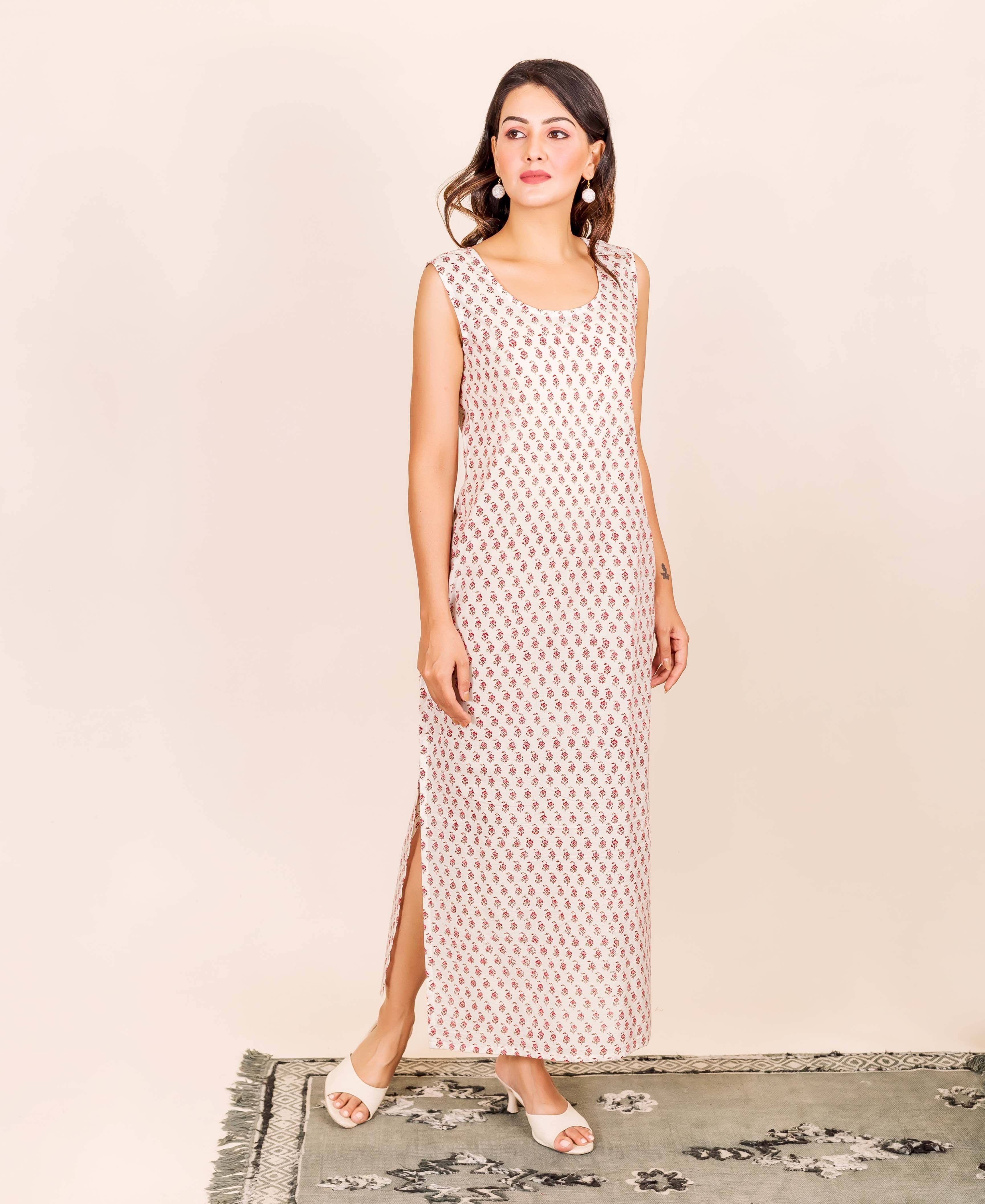 Model in an off-white sleeveless maxi dress with small red hand-block floral print.