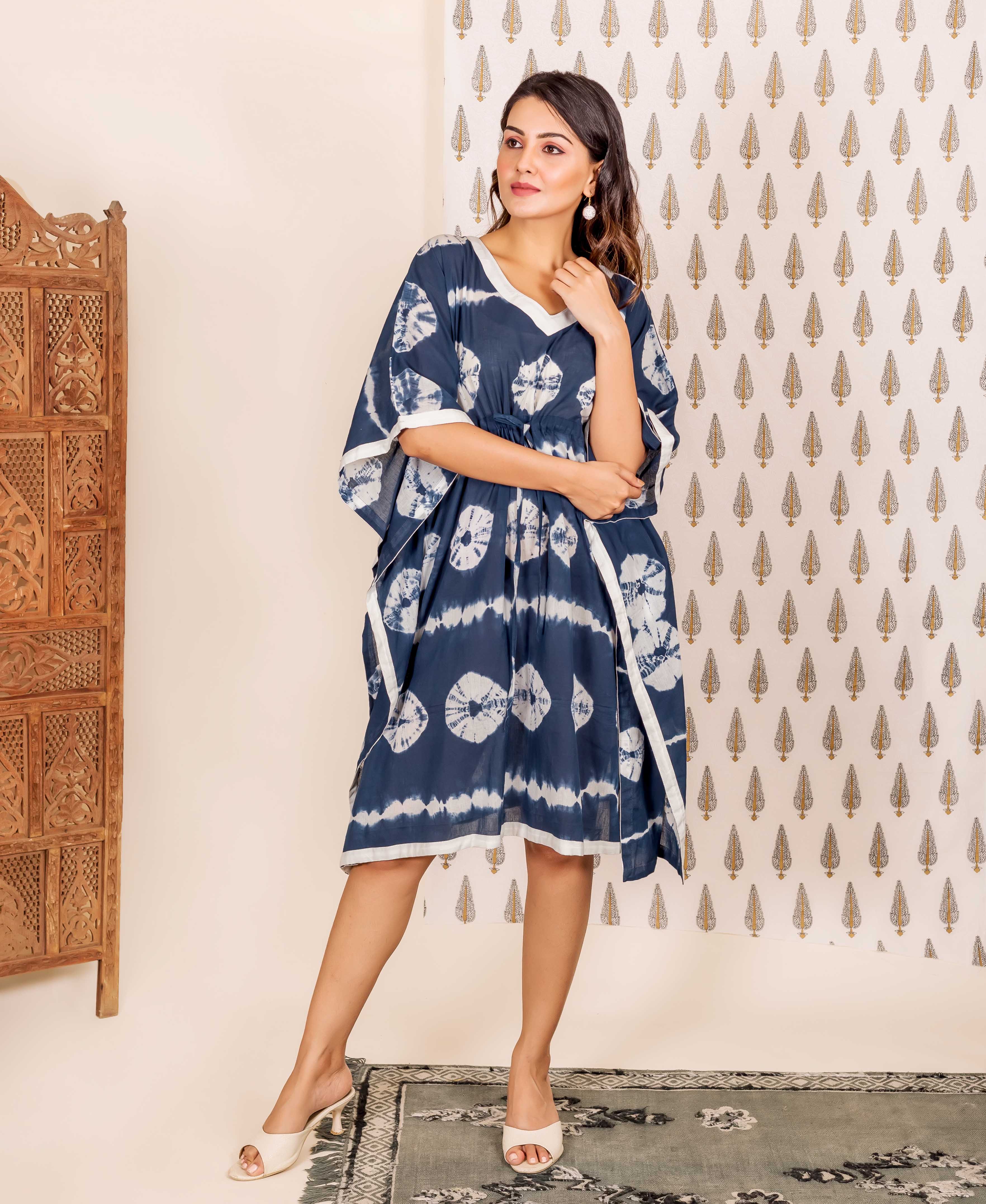 Navy blue kaftan with white tie-dye patterns and white trim on a female model.