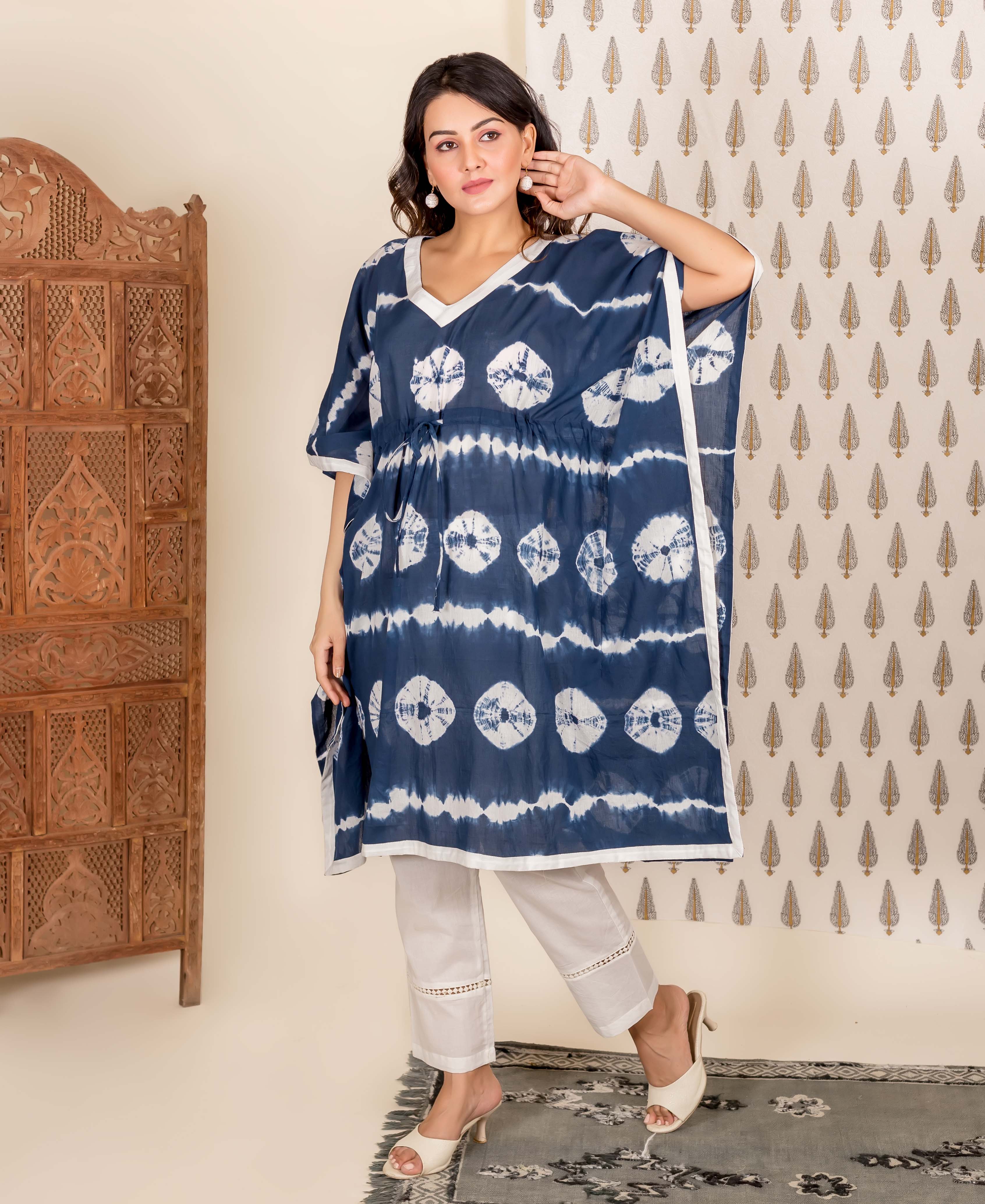 Model wearing navy blue and white tie-dye kaftan and white pants, full front view.