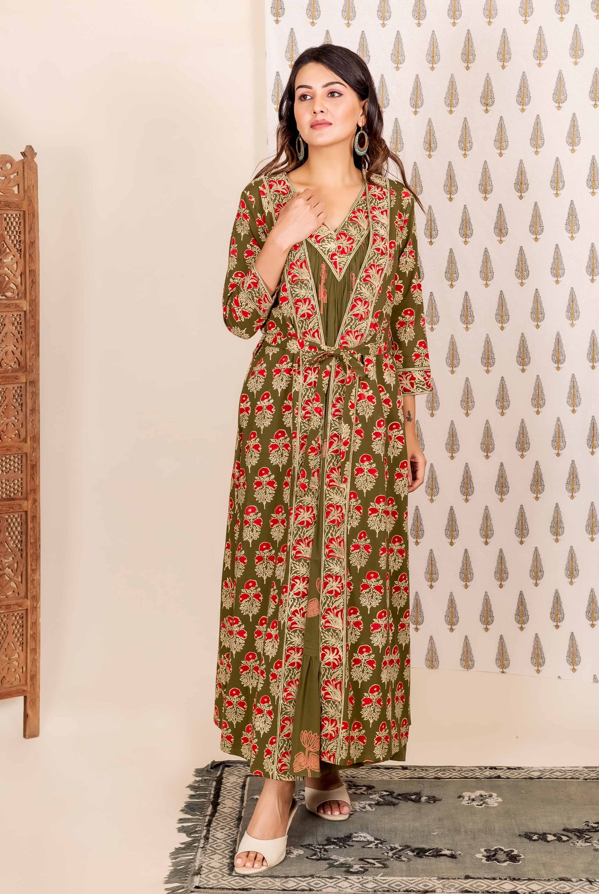 Woman wears olive green and red hand-block printed ethnic long dress with tied overlay.