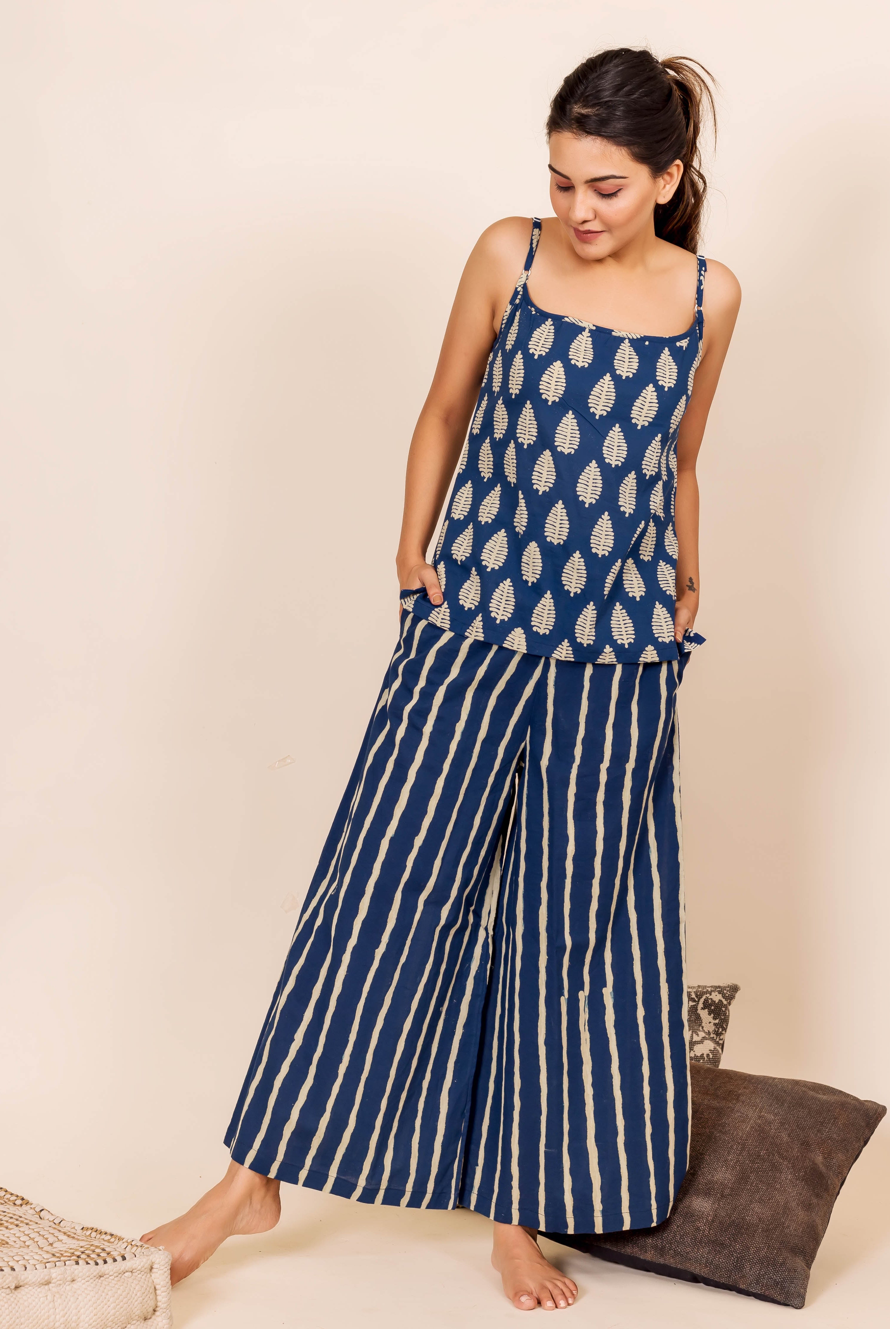 Full-body shot of model wearing indigo hand block printed leaf top and striped pants nightwear.