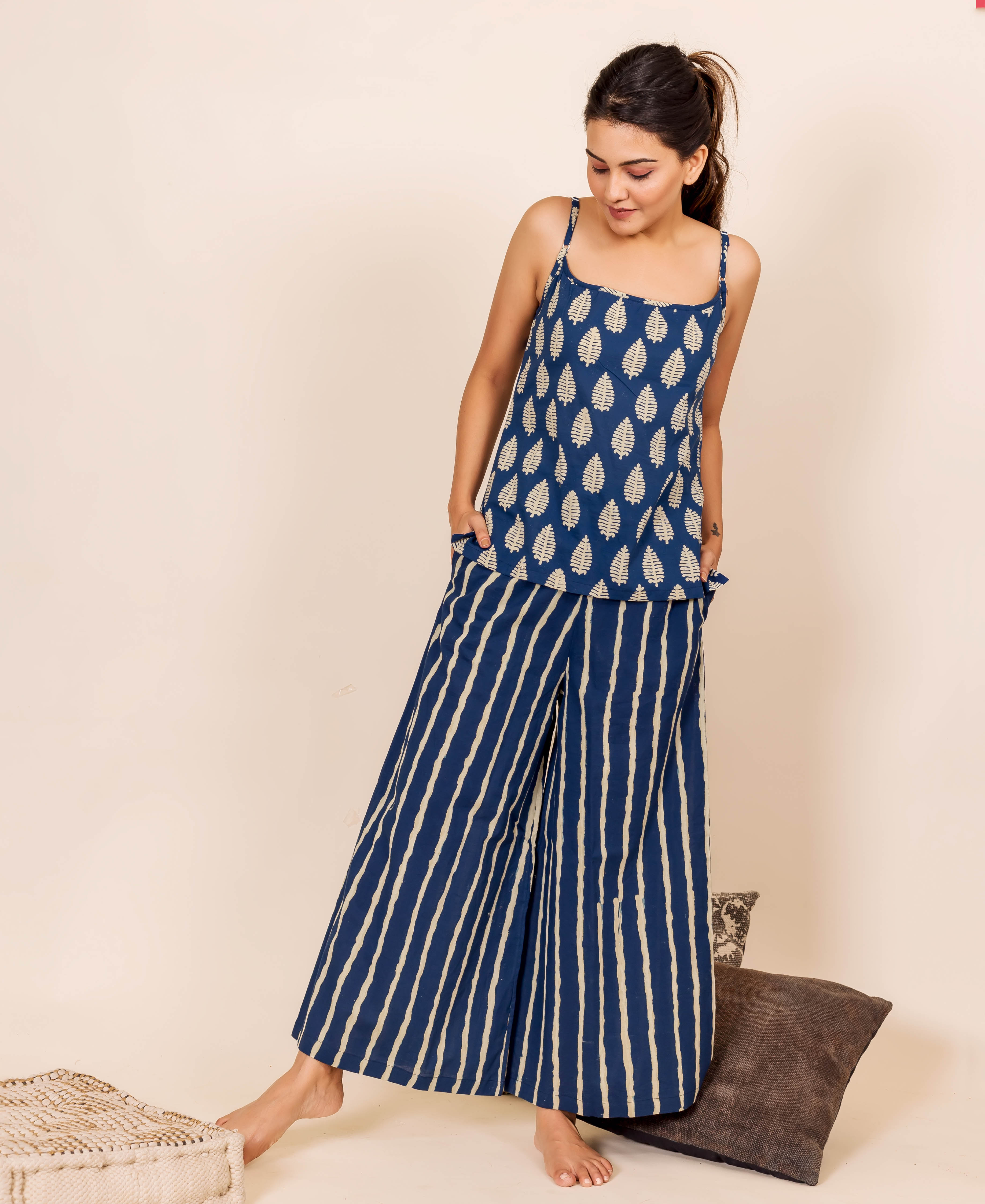 Full-body shot of model wearing indigo hand block printed leaf top and striped pants nightwear.