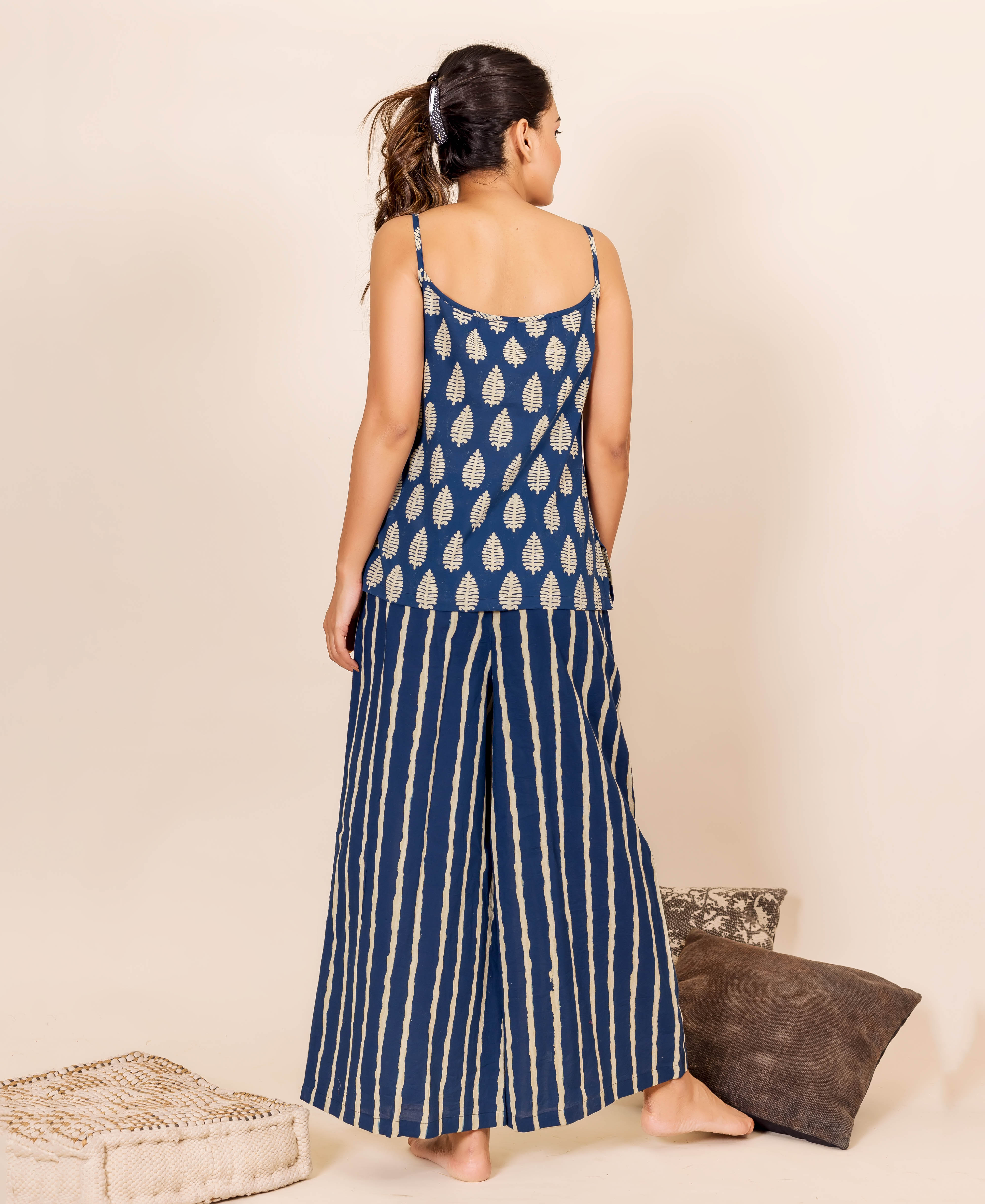 Back view of model wearing indigo block-printed leaf camisole and striped palazzo pants set.