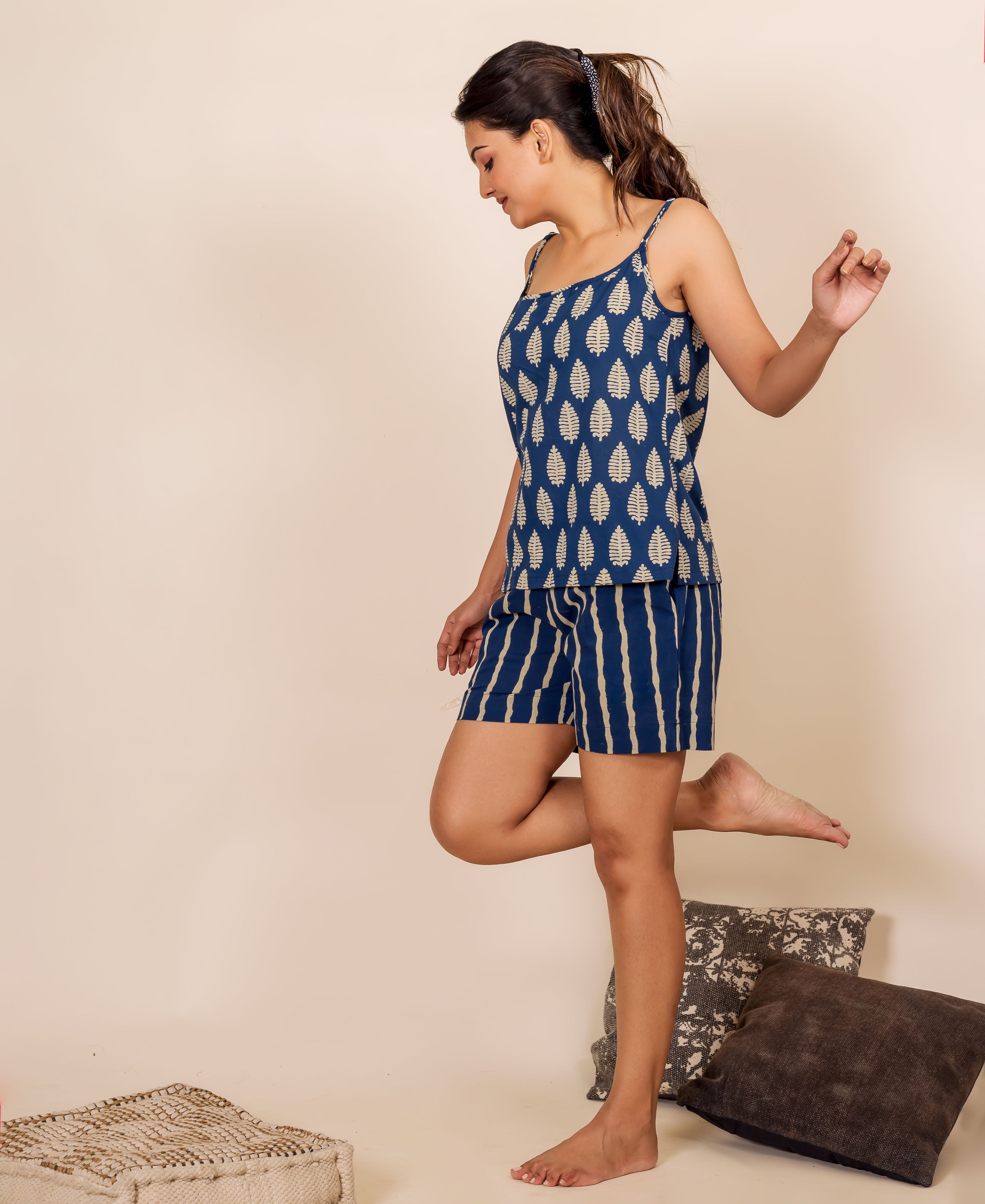 Side view of model in indigo hand block printed leaf camisole and striped shorts.