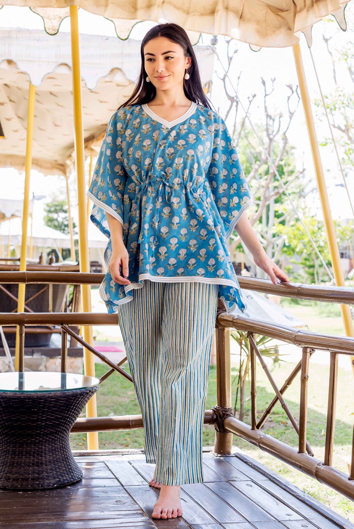 Model wearing blue hand-block printed floral kaftan top with striped trousers.