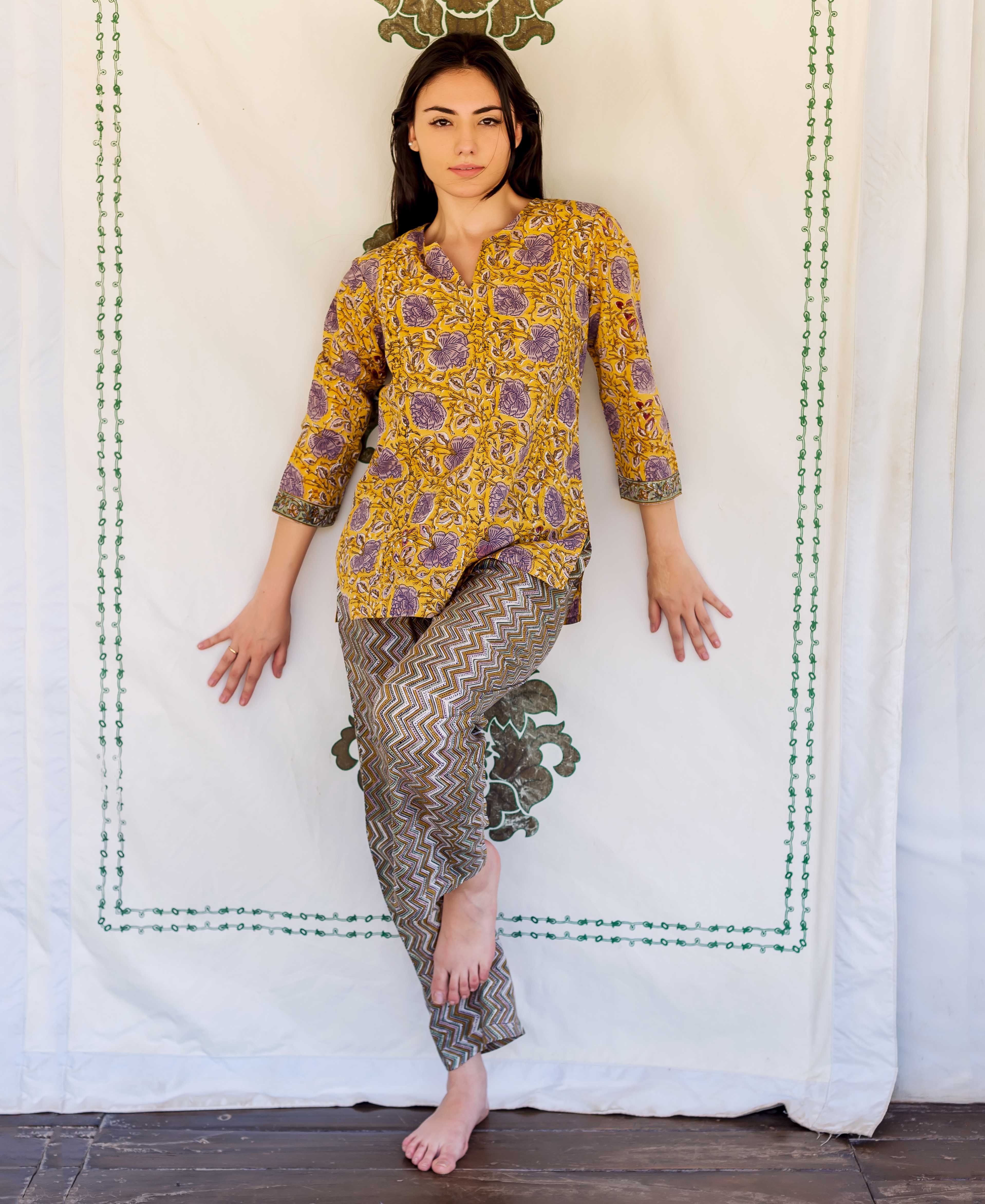 Model wears yellow hand-block printed floral lounge wear top and olive green zigzag pants.