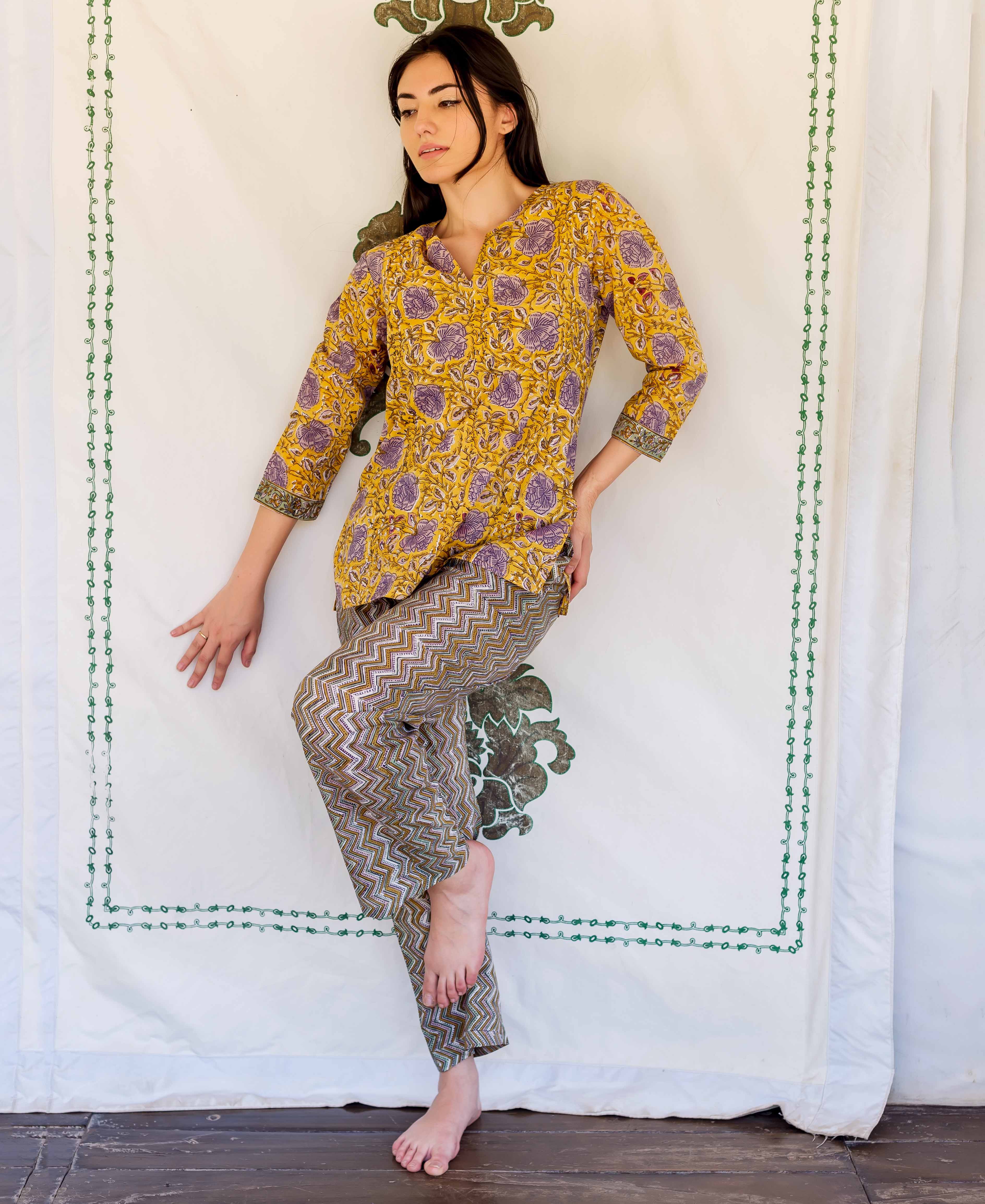 Model wears yellow hand block printed floral tunic and brown zigzag lounge pants.