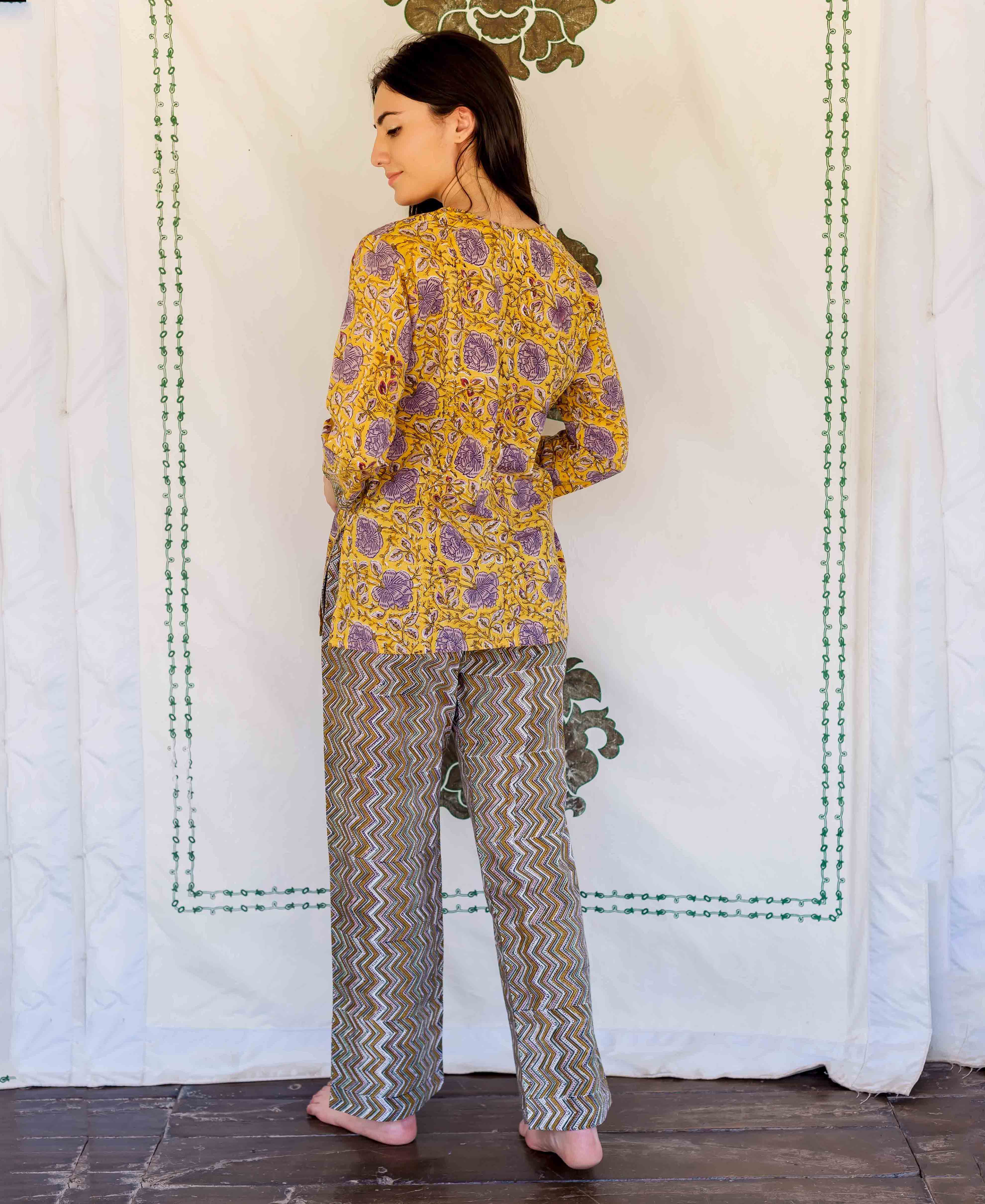 Rear view of model in yellow floral hand block print top and patterned zig-zag lounge pants.