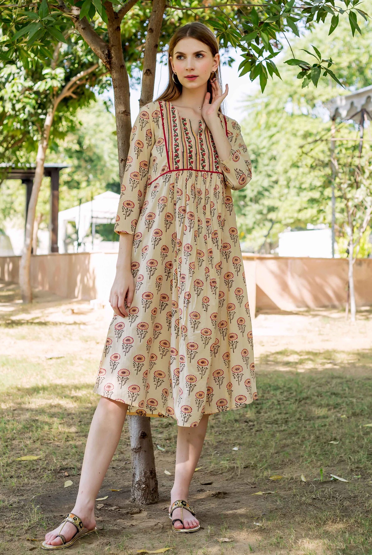 Standing model in a cream hand-block-printed dress with multicolour floral pattern.